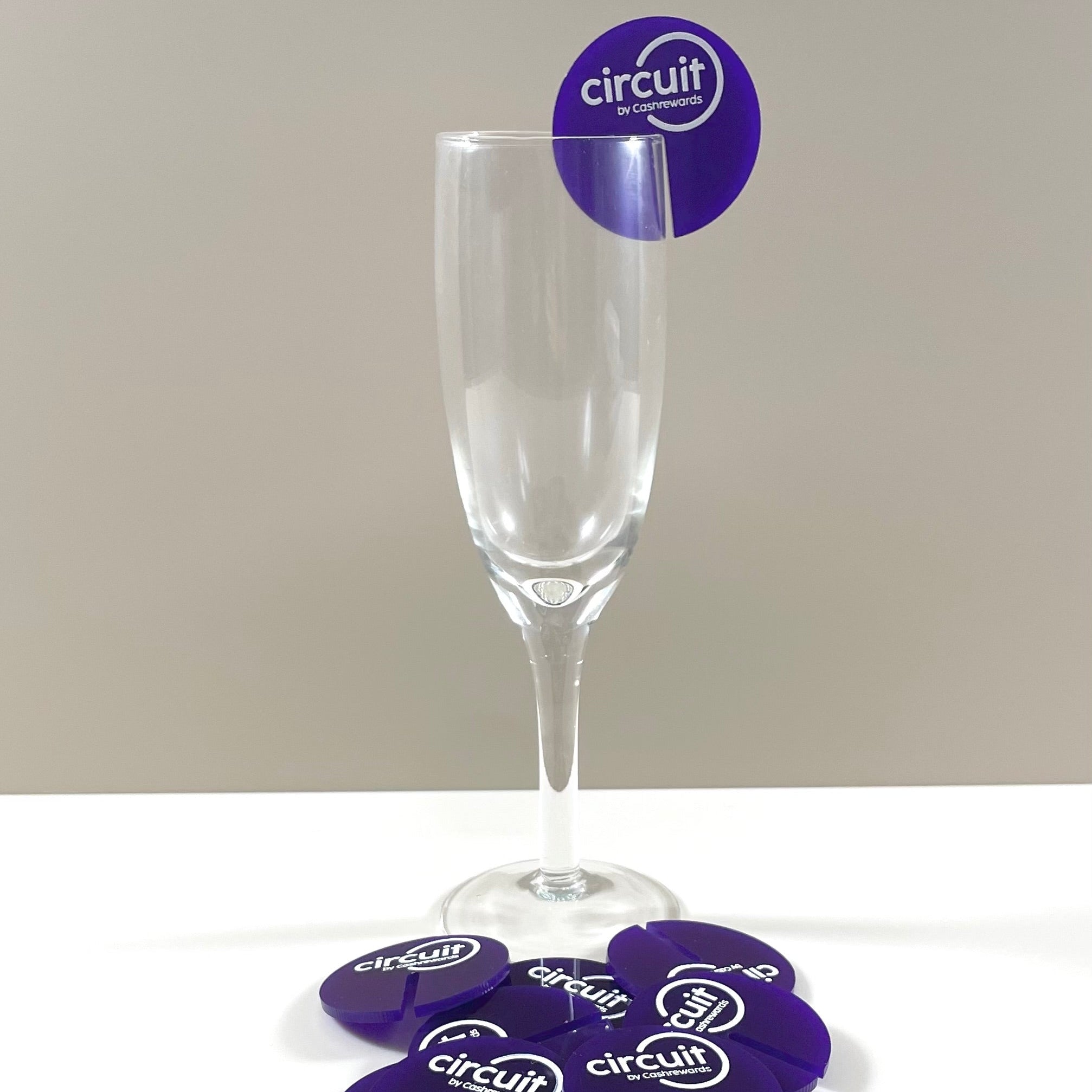 Purple branded drink tag on a champagne flute