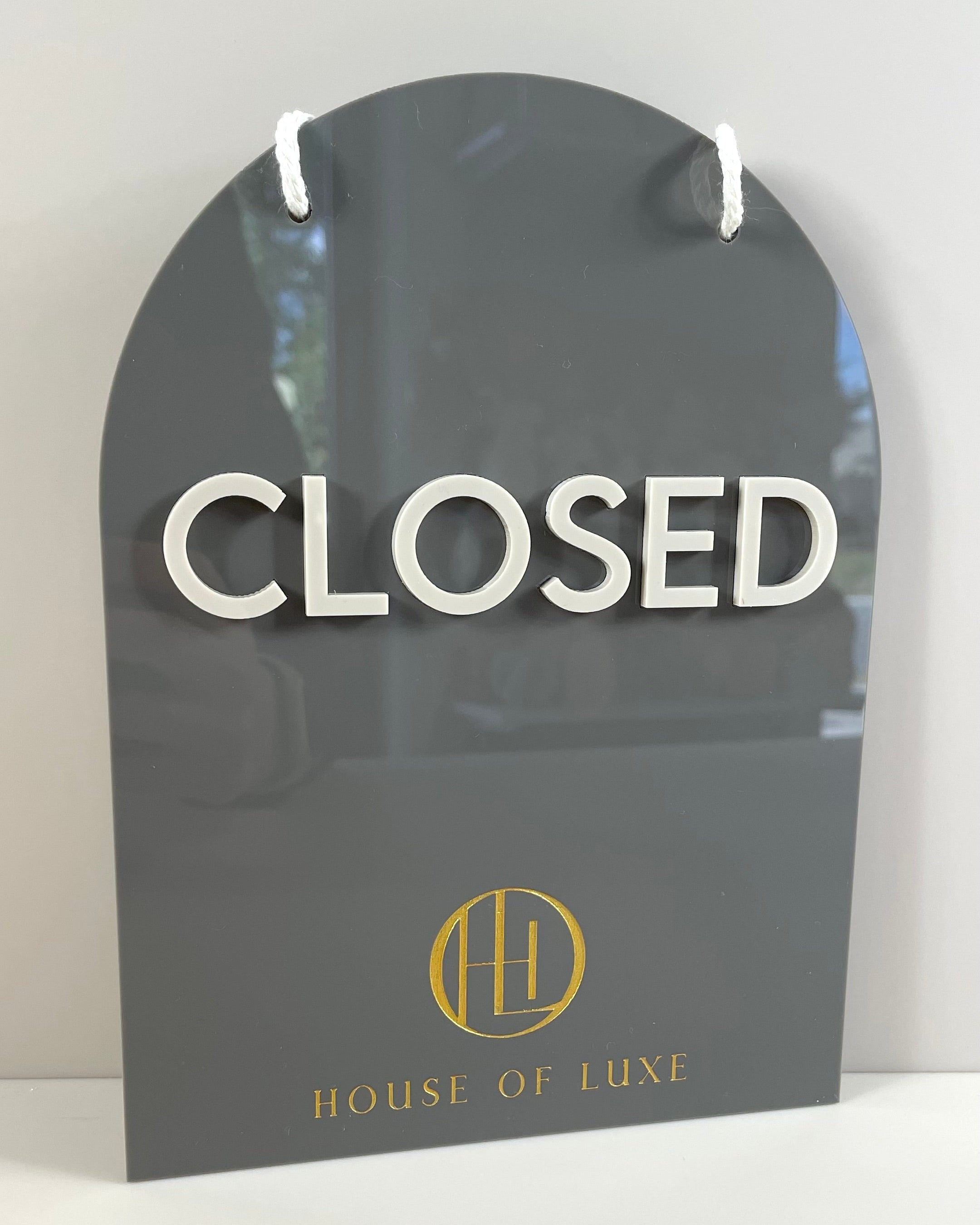 Arched black acrylic closed sign with gold logo – modern business signage