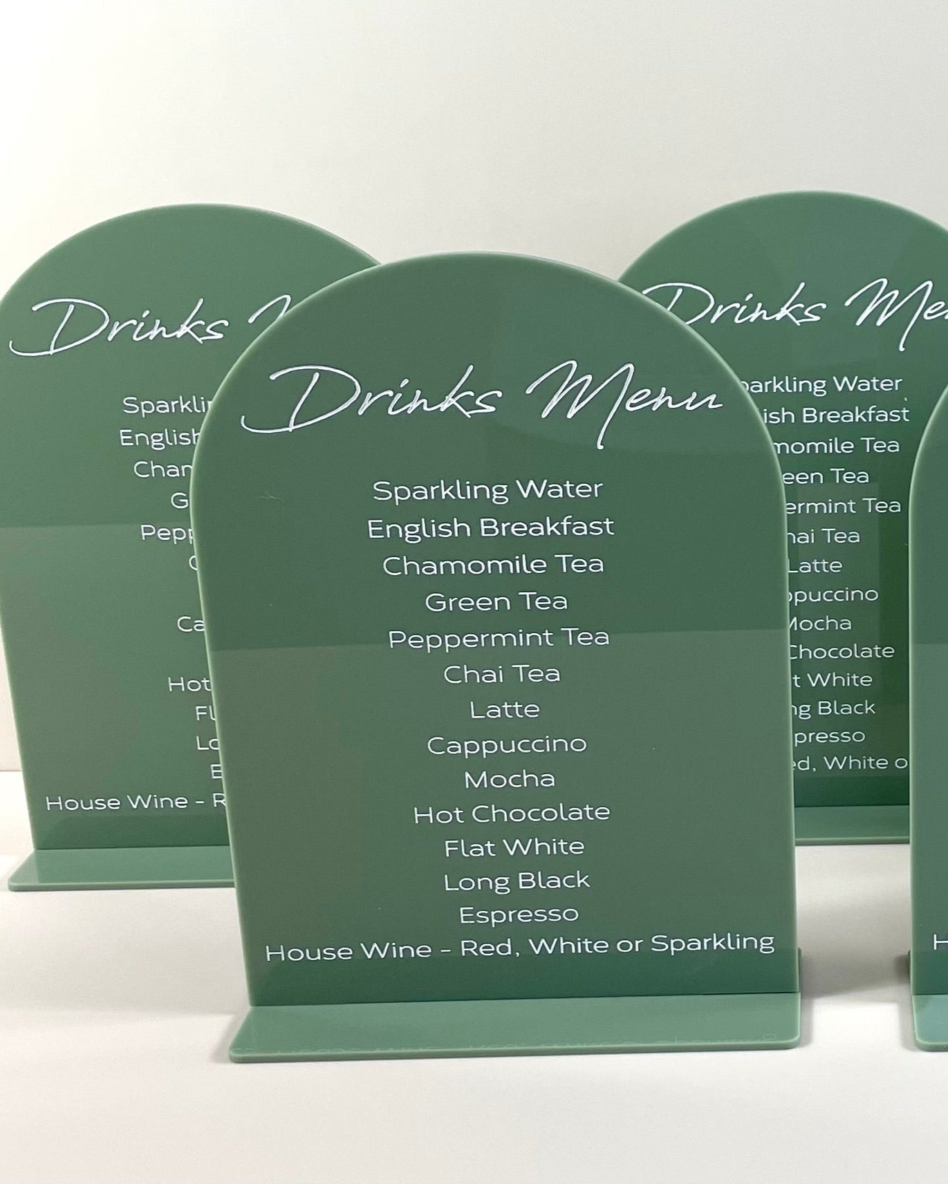 Matching green acrylic drink menus with white engraved text for coffee stand