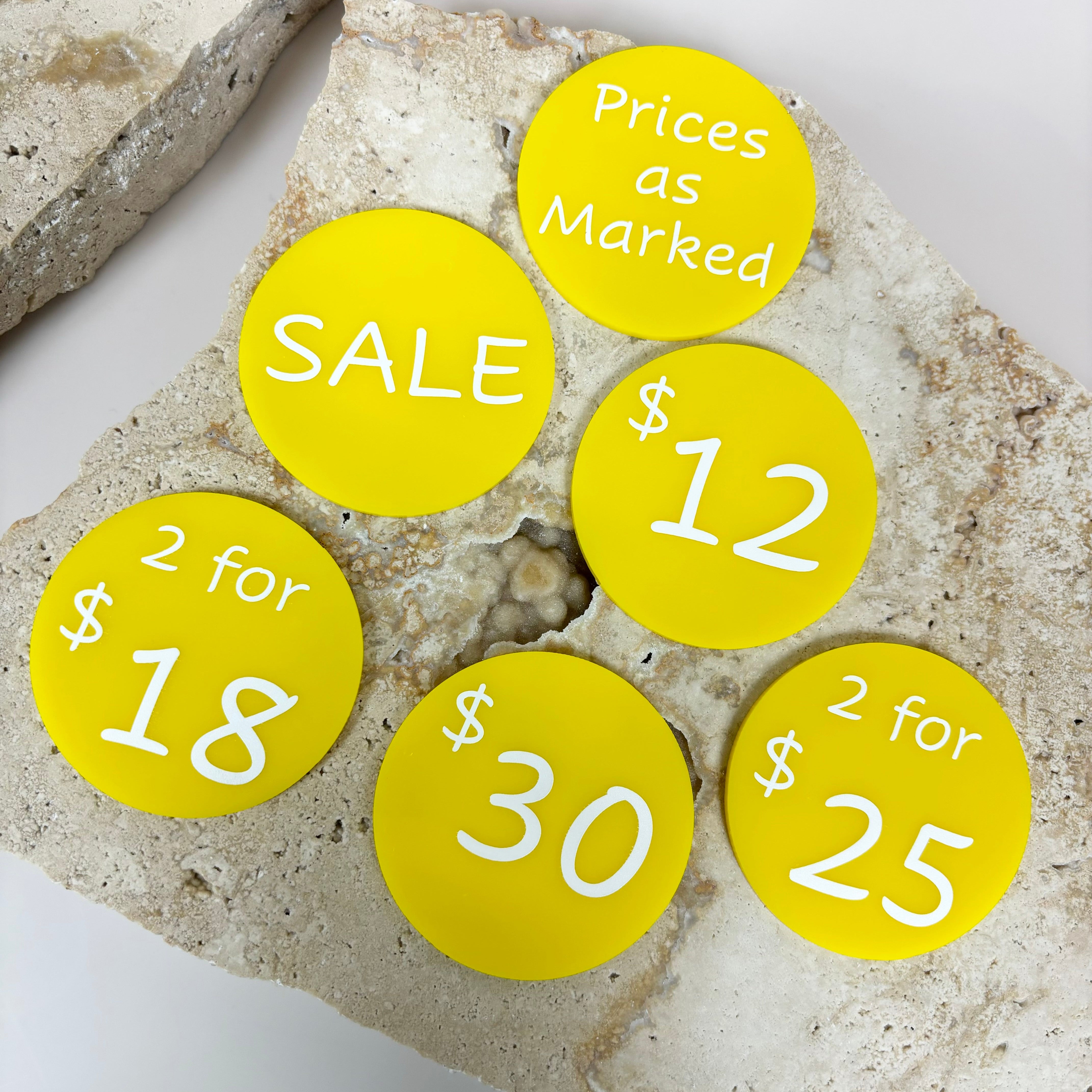 Bright yellow price discs showing sale pricing for market stalls