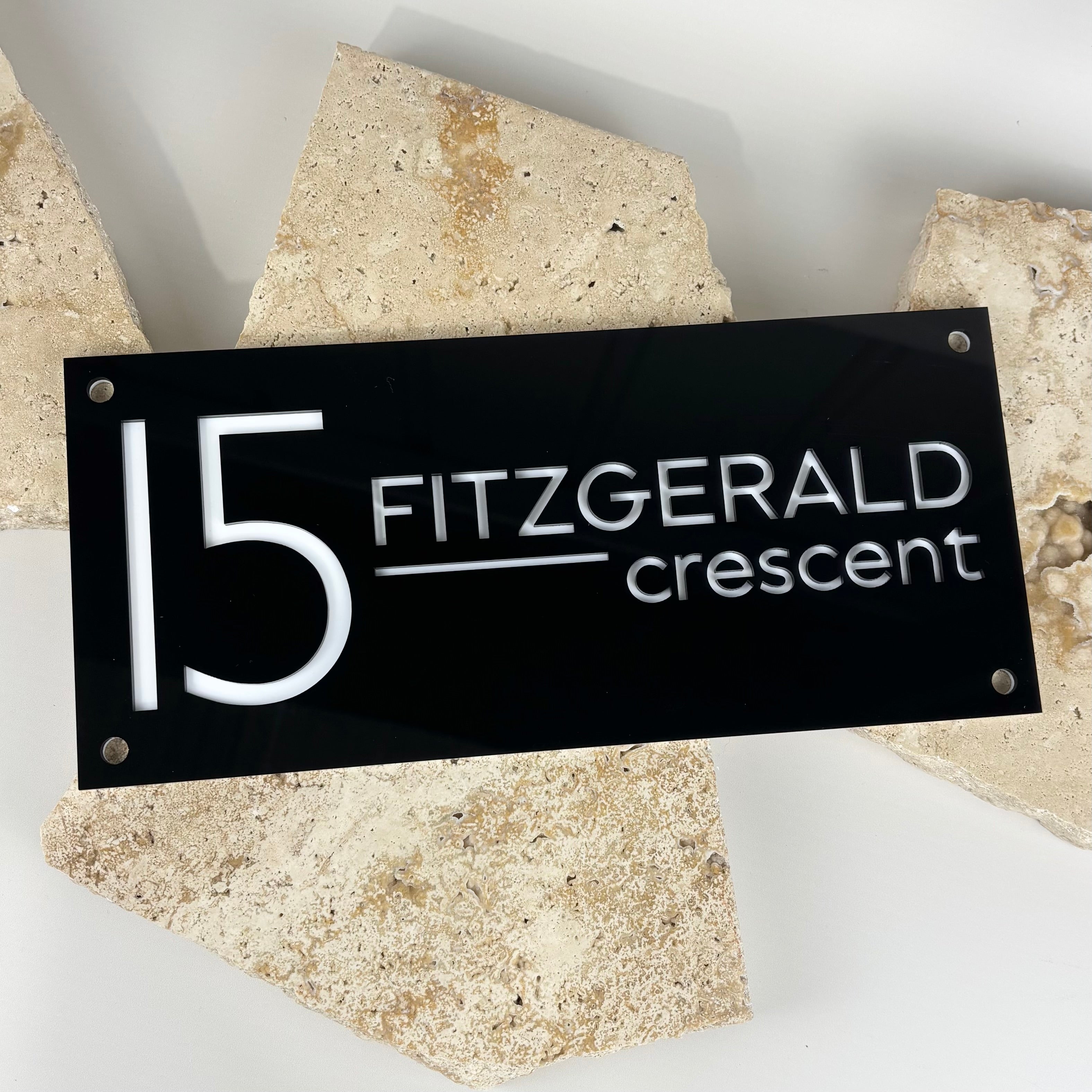 Modern black acrylic house number sign with white engraved text displaying 15 Fitzgerald Crescent, custom laser-cut address plaque for home exterior