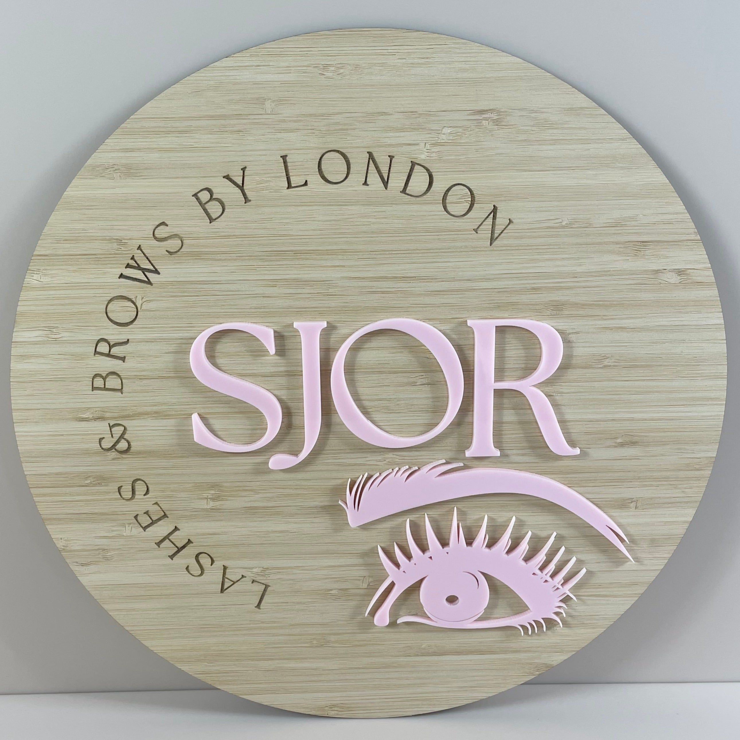 SJOR Lashes & Brows by London bamboo sign with pink eye and lash logo in acrylic