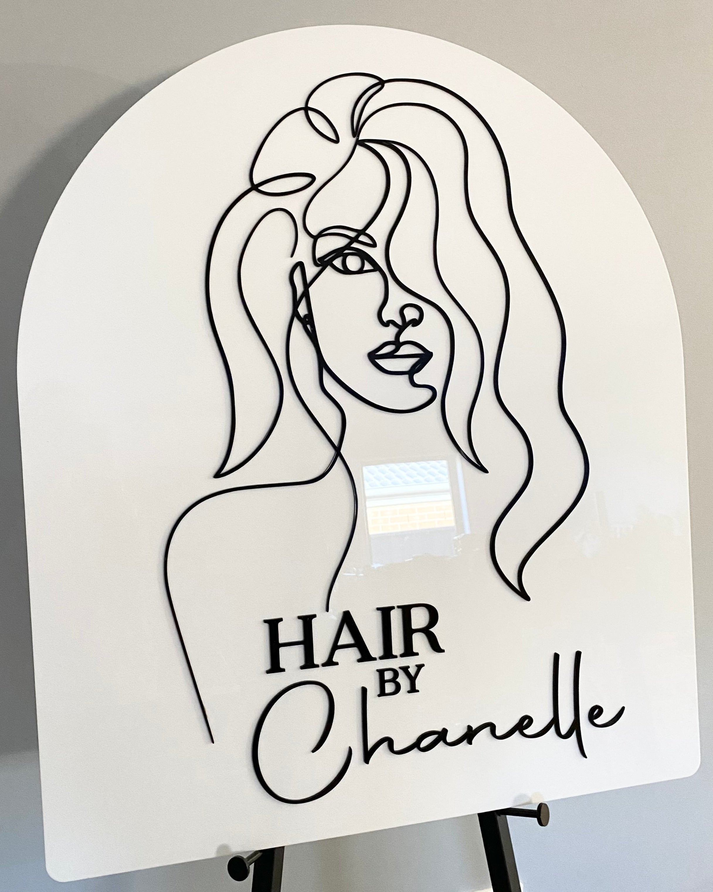White arched sign with female face line art