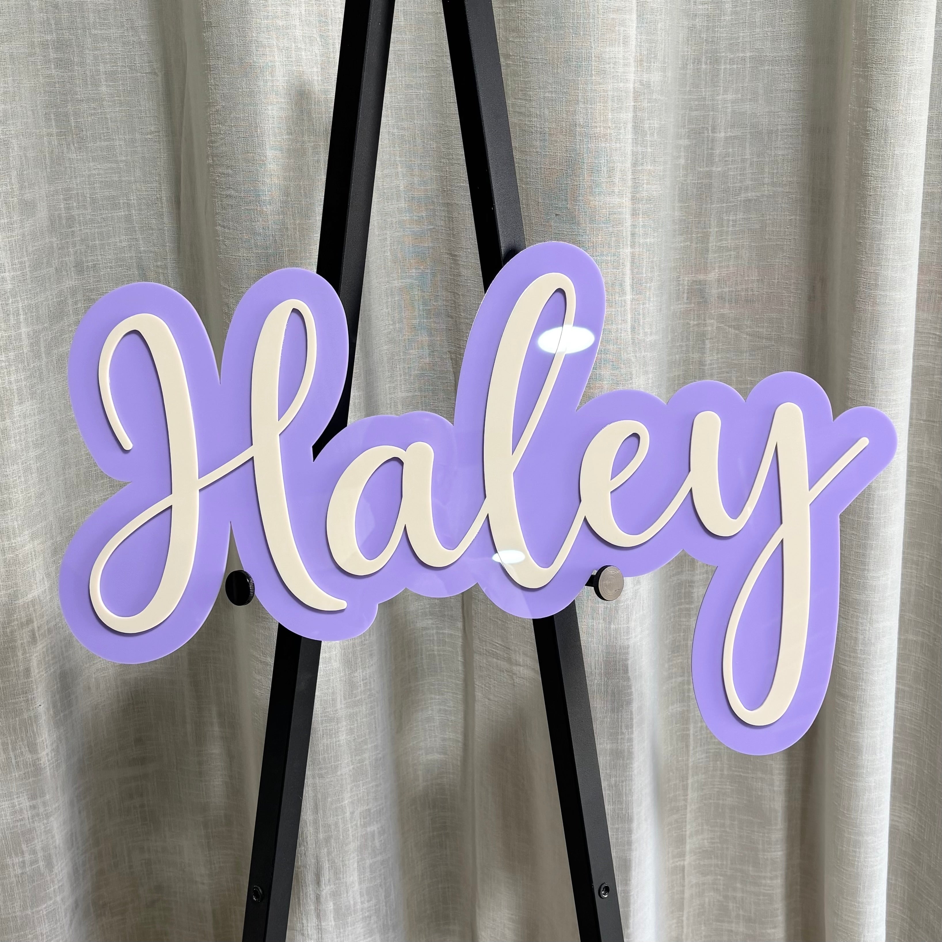 Custom layered acrylic name sign for kids bedroom decor in pastel purple and white. Personalised script name plaque for nursery wall decor, playroom styling, baby room signs and custom acrylic name signage handmade in Australia.
