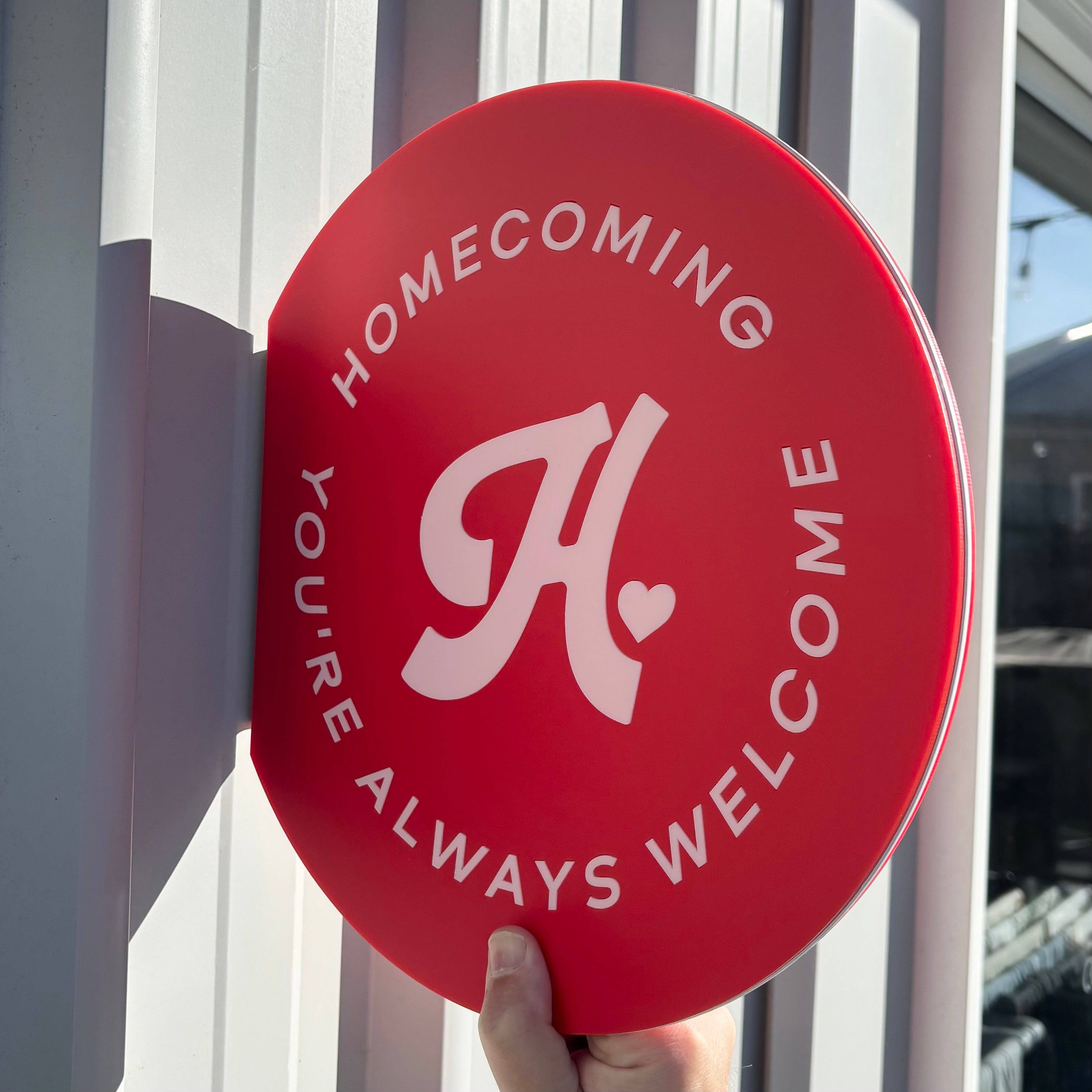 Round acrylic blade business sign mounted outdoors