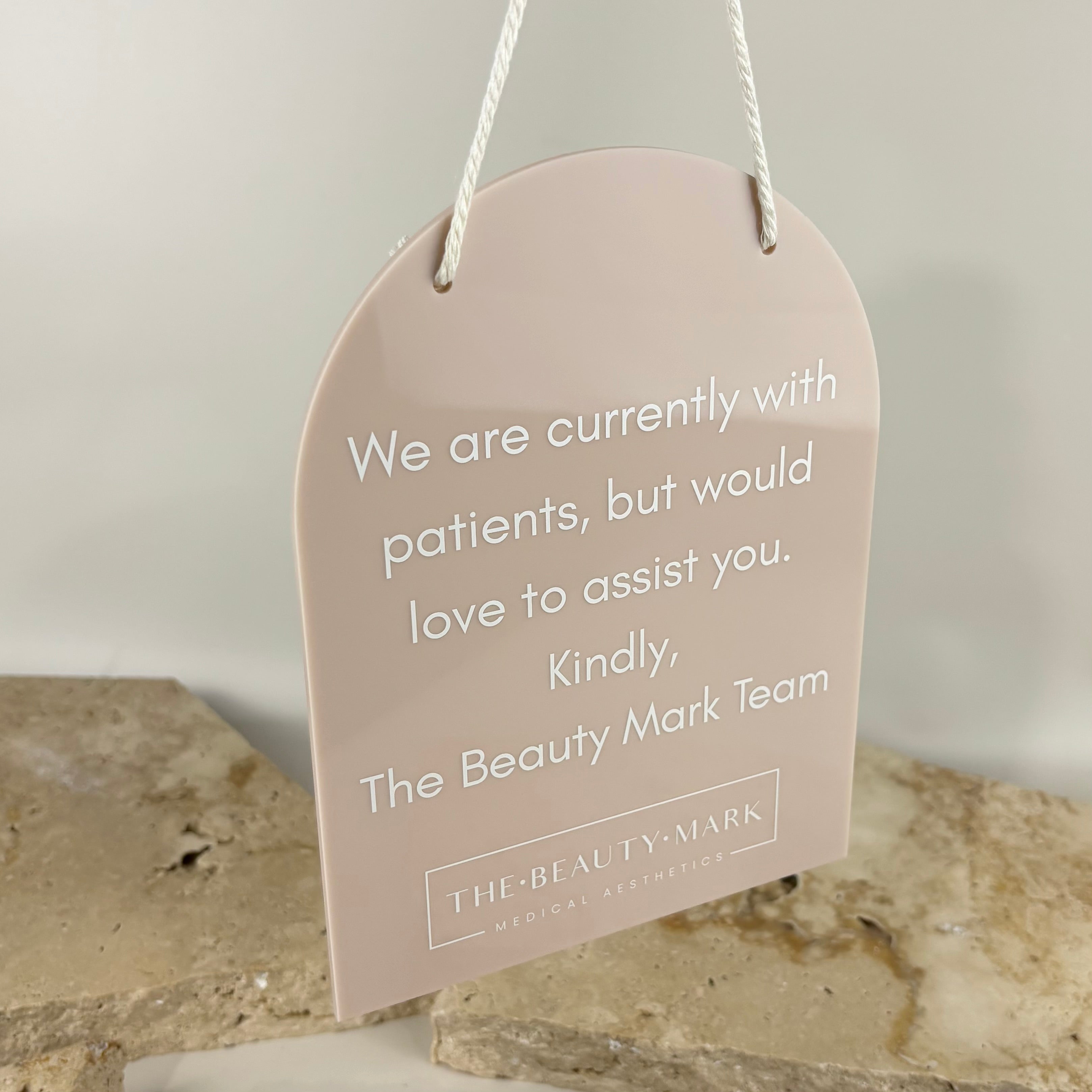 Custom blush acrylic hanging door sign for medical aesthetics clinic, arch shape sign with rope hanger, “currently with patients” message, professional clinic door signage, modern beauty business signage Australia