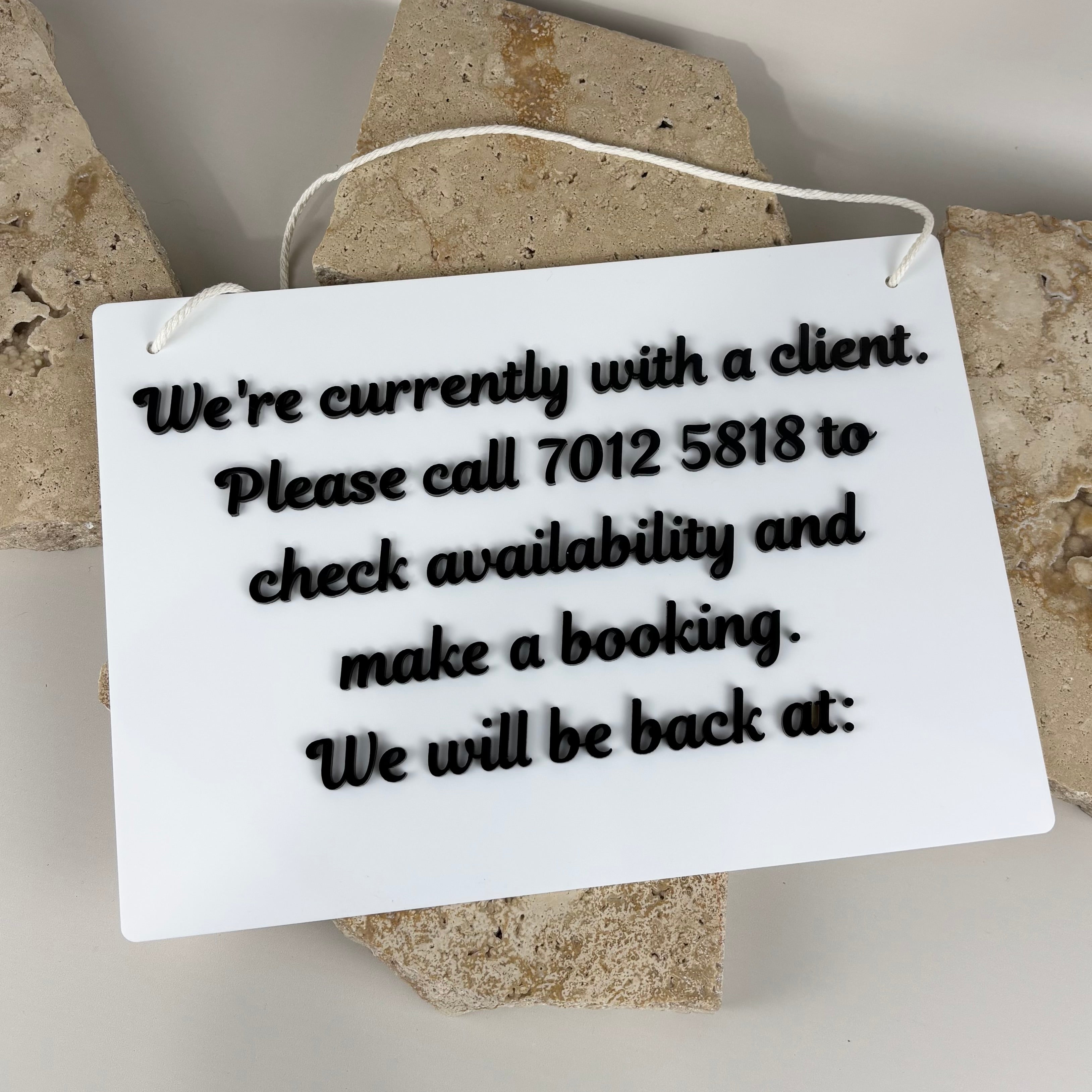 Custom acrylic salon door sign with we’re with a client message, personalised business signage with contact details and booking information.