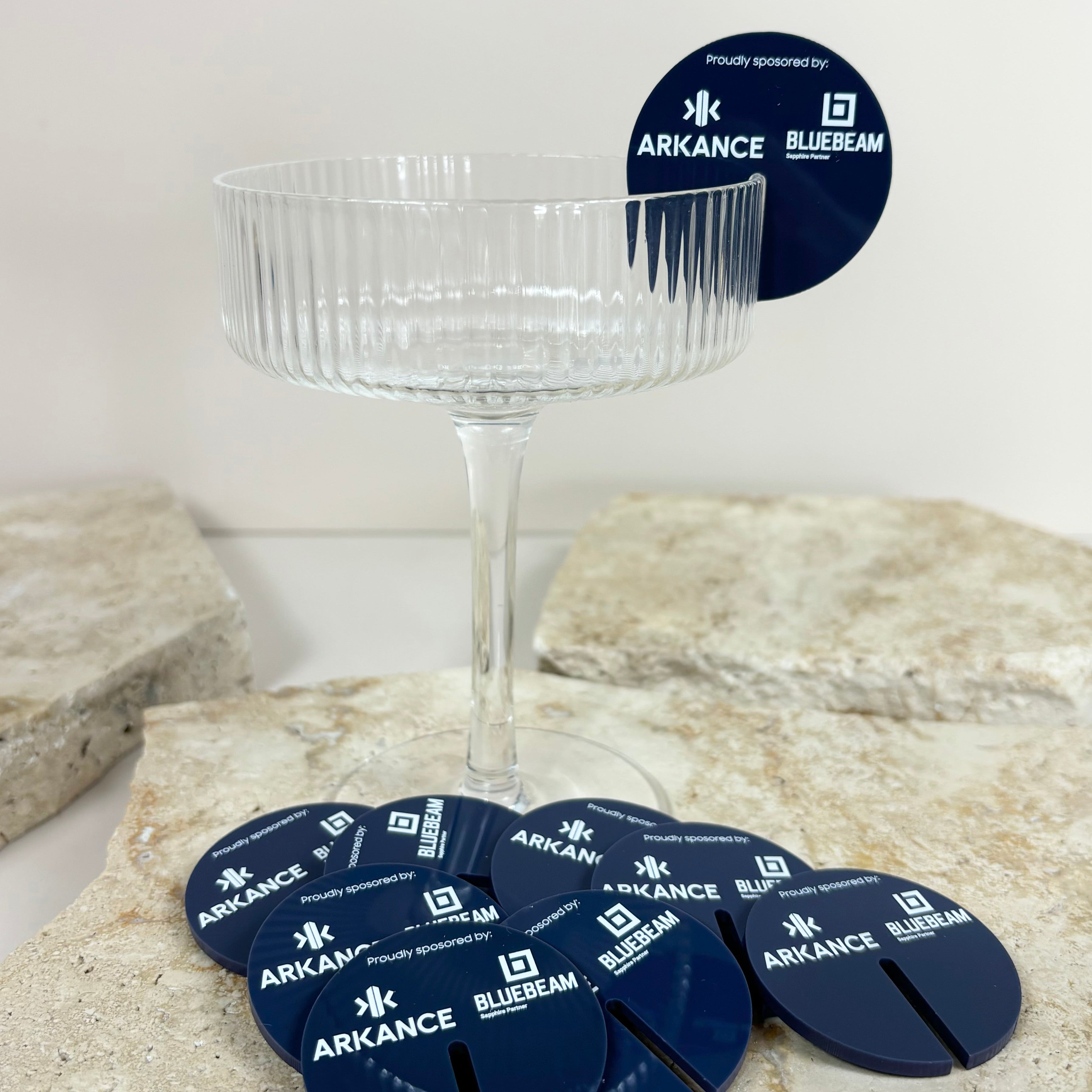Navy logo drink tags arranged on a clear cocktail glass