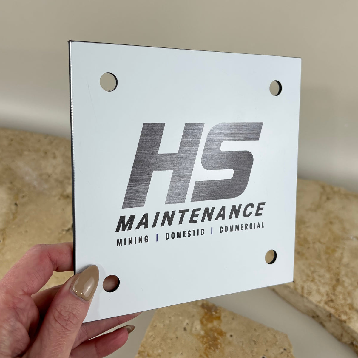Custom printed aluminium business sign for HS Maintenance with mounting holes and brushed metal logo finish.