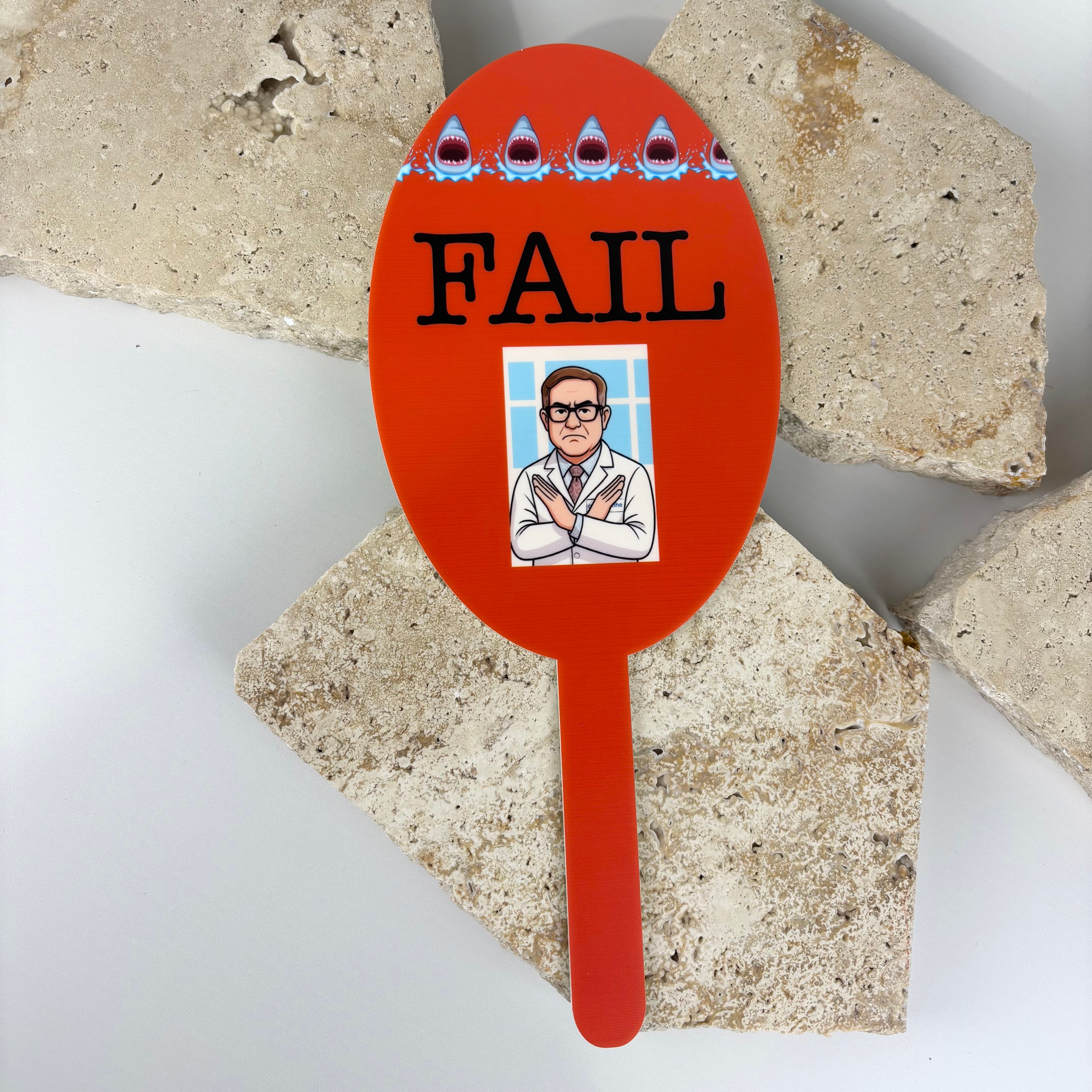 Red FAIL paddle with cartoon doctor crossing arms, used for vision or eye test results