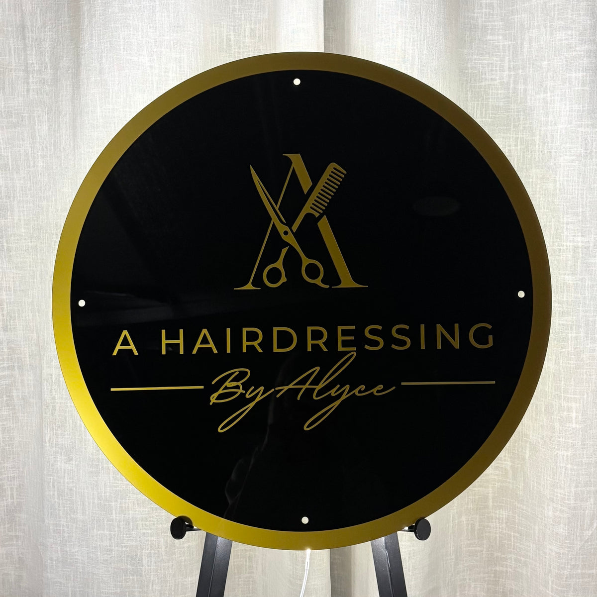 Custom round black acrylic business sign with gold border and gold hairdressing logo for A Hairdressing By Alyce, designed for salon branding.