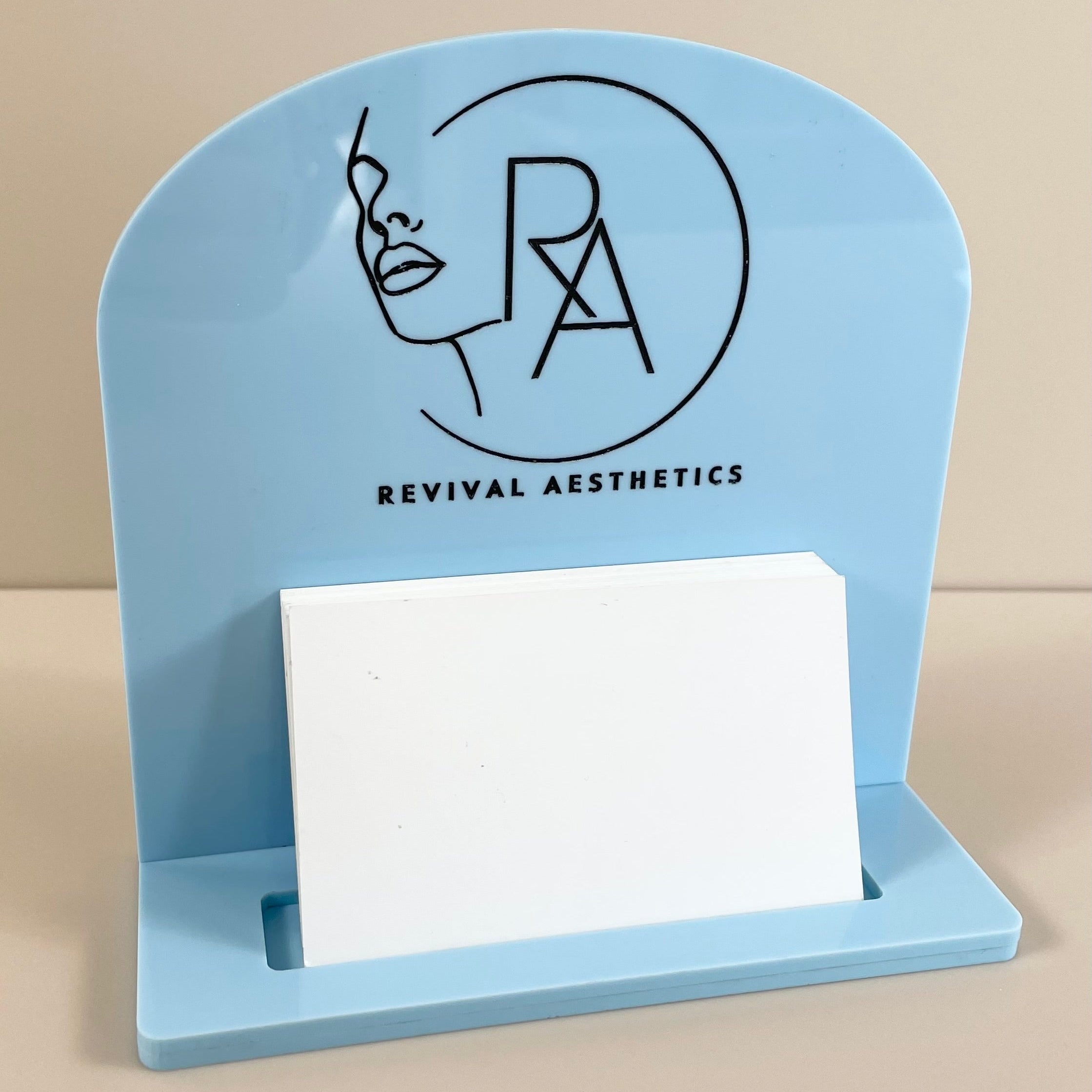 Blue acrylic business card holder with facial aesthetic logo