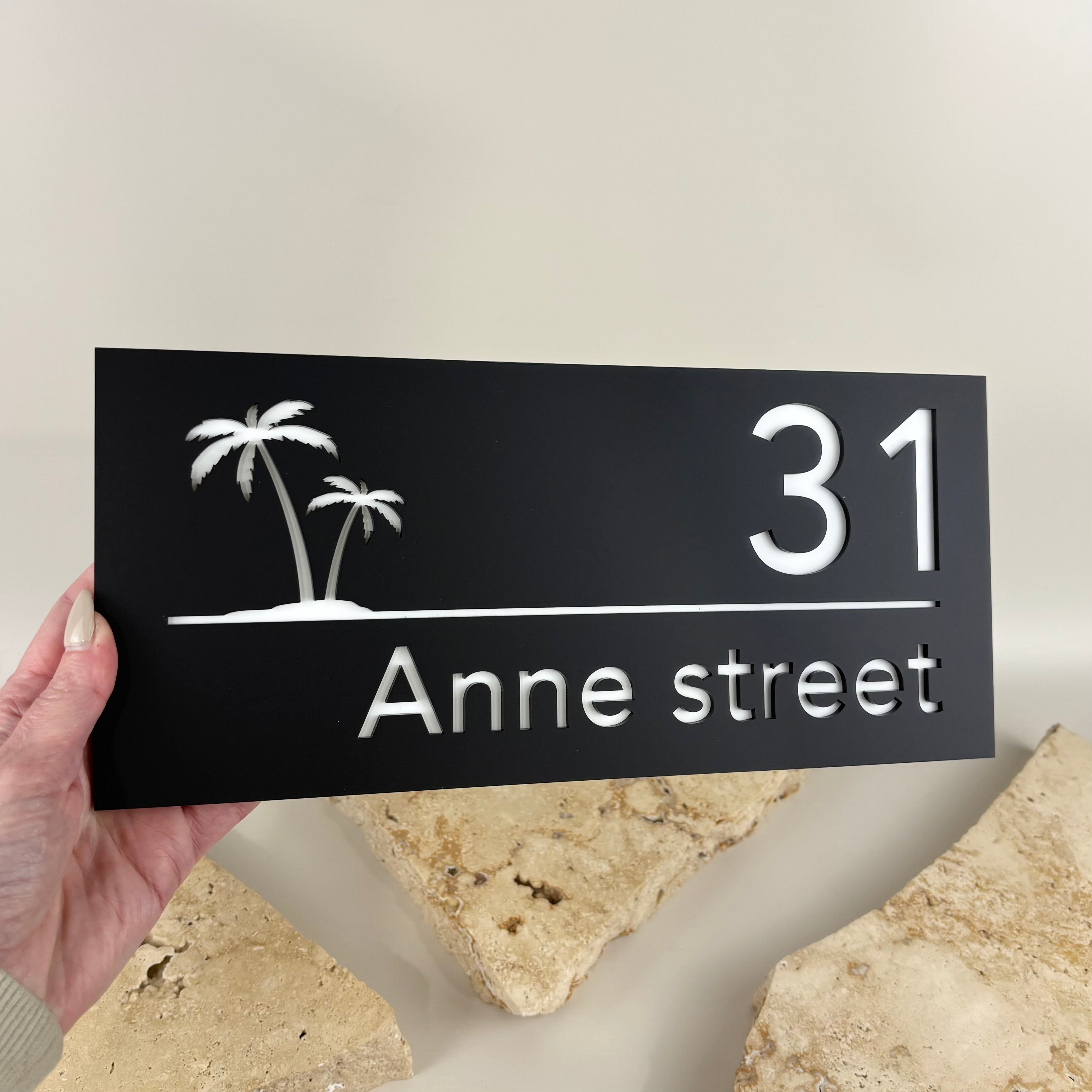 Modern custom black acrylic address sign with white raised 3D house number and street name, featuring a laser-cut palm tree design. Premium personalised house address plaque for front entrances, fences, gates and letterboxes, providing durable outdoor home signage with a contemporary finish.