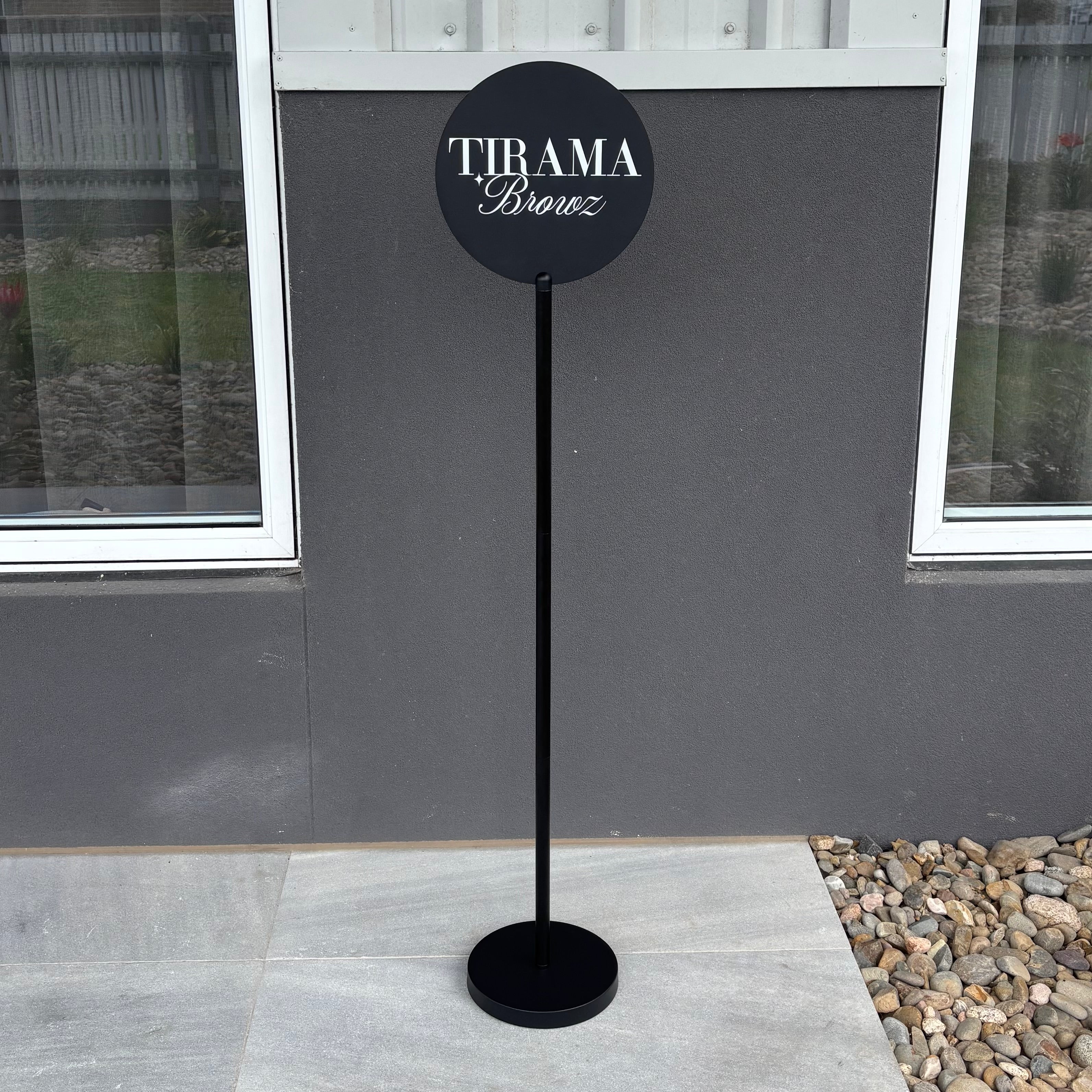 Black acrylic logo sign on metal display stand for indoor or outdoor salon signage.