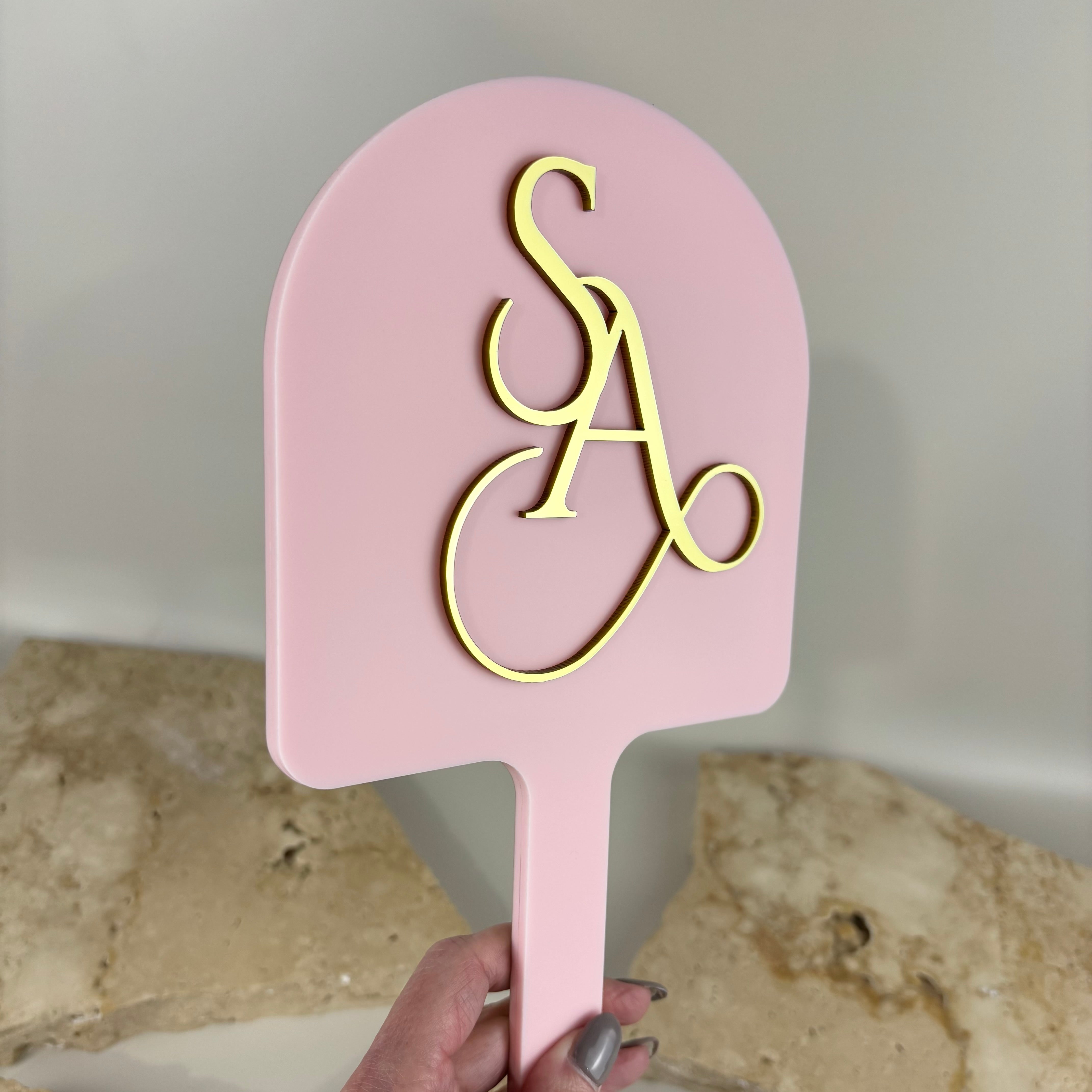 Custom arched acrylic handheld mirror with raised 3D logo, blush pink salon mirror with gold acrylic lettering, branded beauty mirror for hairdressers and makeup artists, luxury salon branding mirror Australia