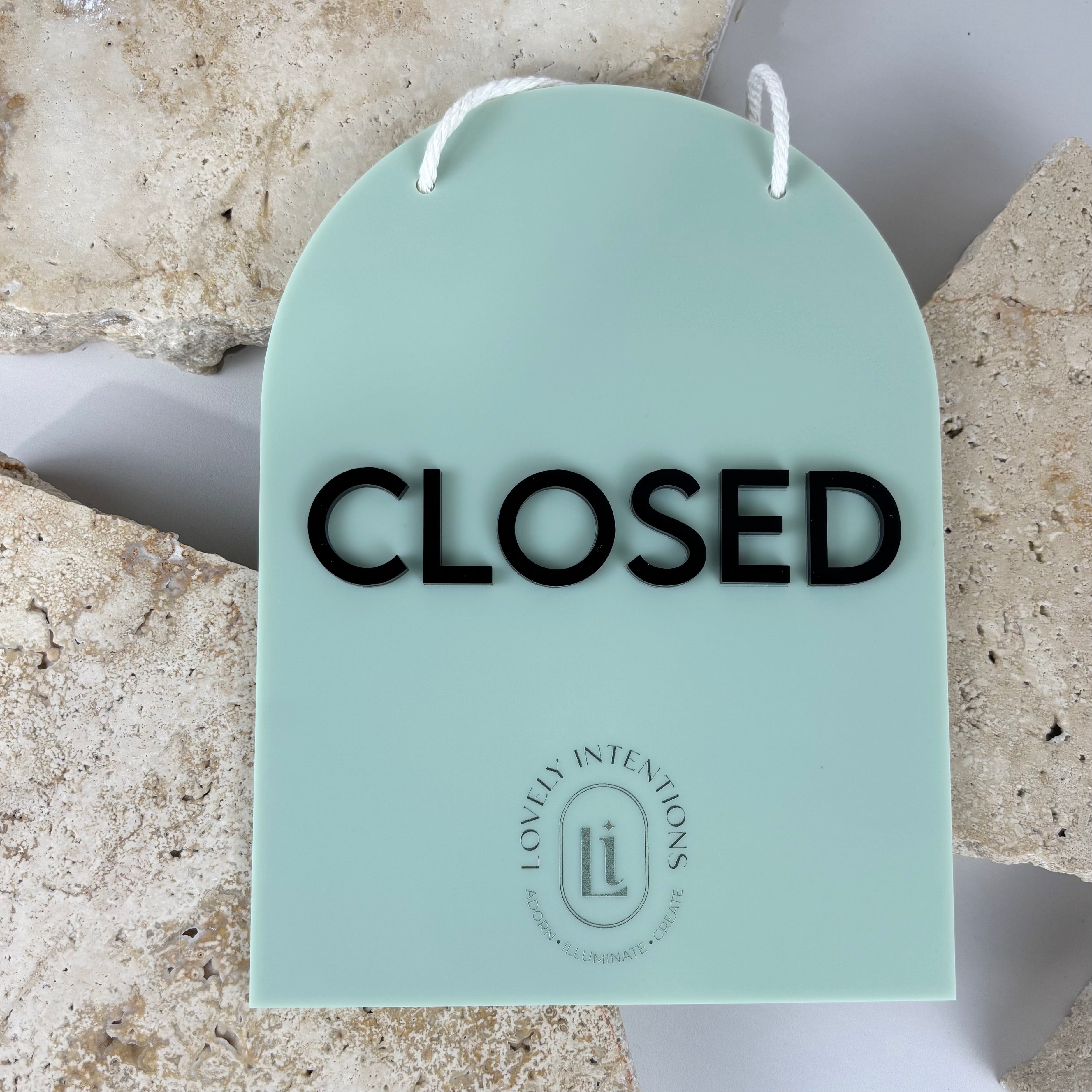 Mint green acrylic closed shop sign with black lettering
