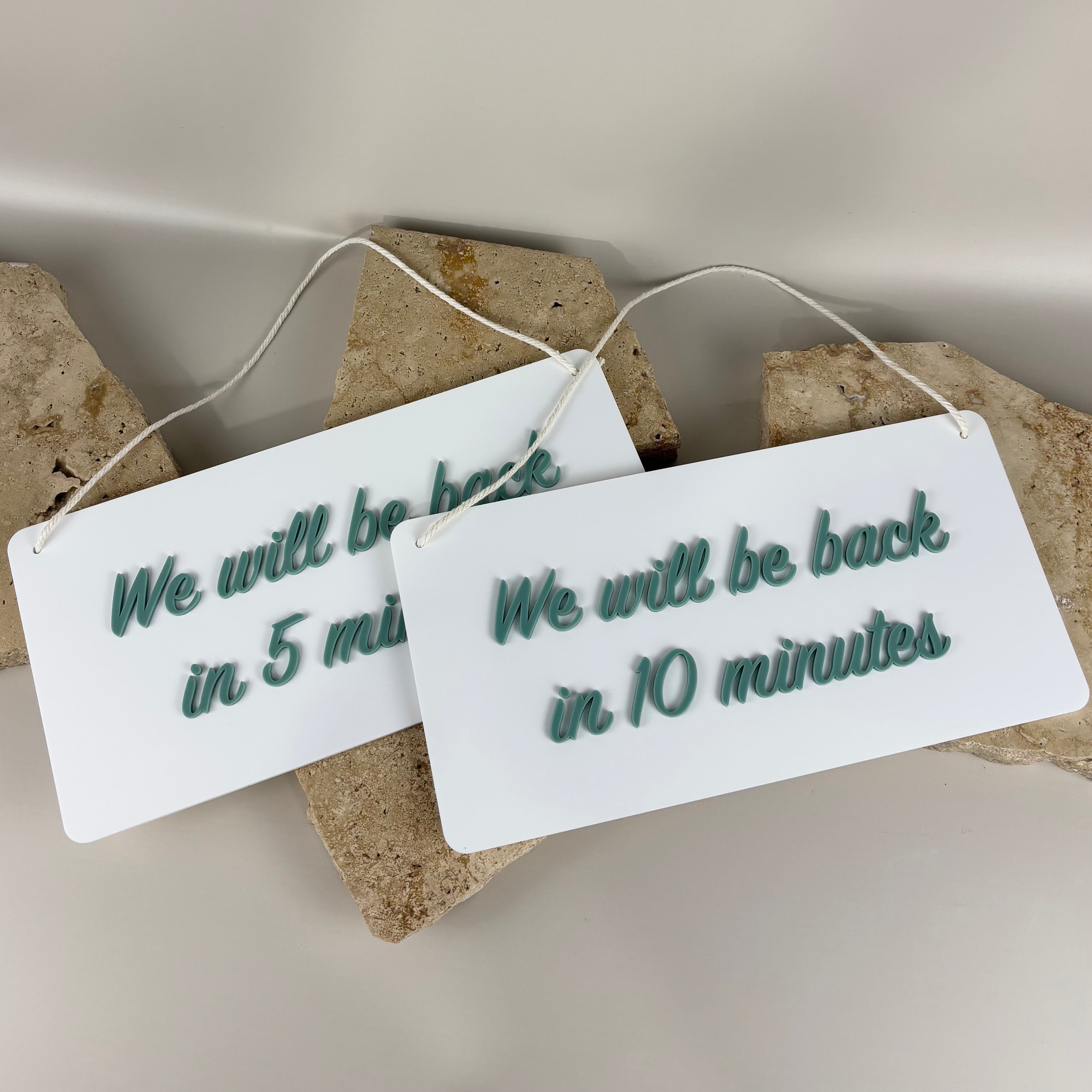 Custom white acrylic business break signs with teal 3D lettering reading We will be back in 5 minutes and We will be back in 10 minutes