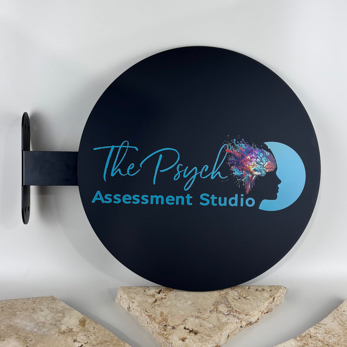 Custom round projecting business sign with a black aluminium panel, wall mounting bracket and vibrant UV printed logo for The Psych Assessment Studio. Premium double-sided outdoor blade sign for psychology clinics, medical practices, allied health providers and professional offices, designed to improve street visibility and brand recognition.