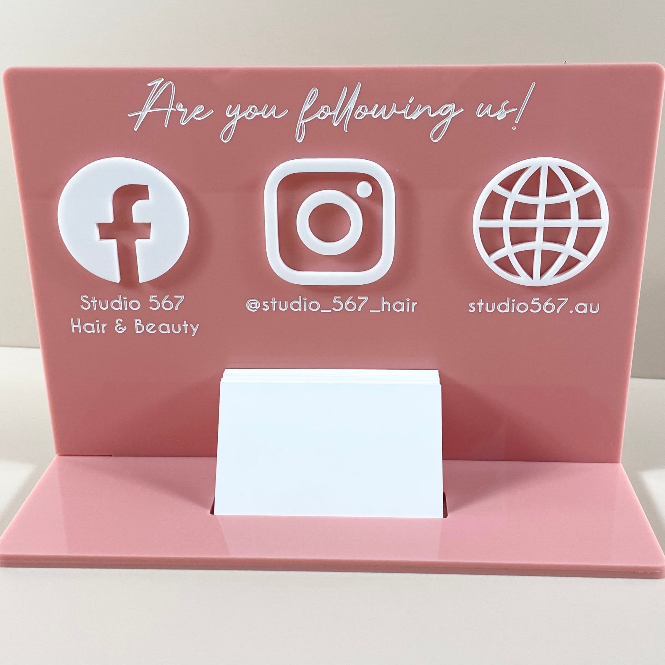 Pink and white social media stand with Facebook and globe icons