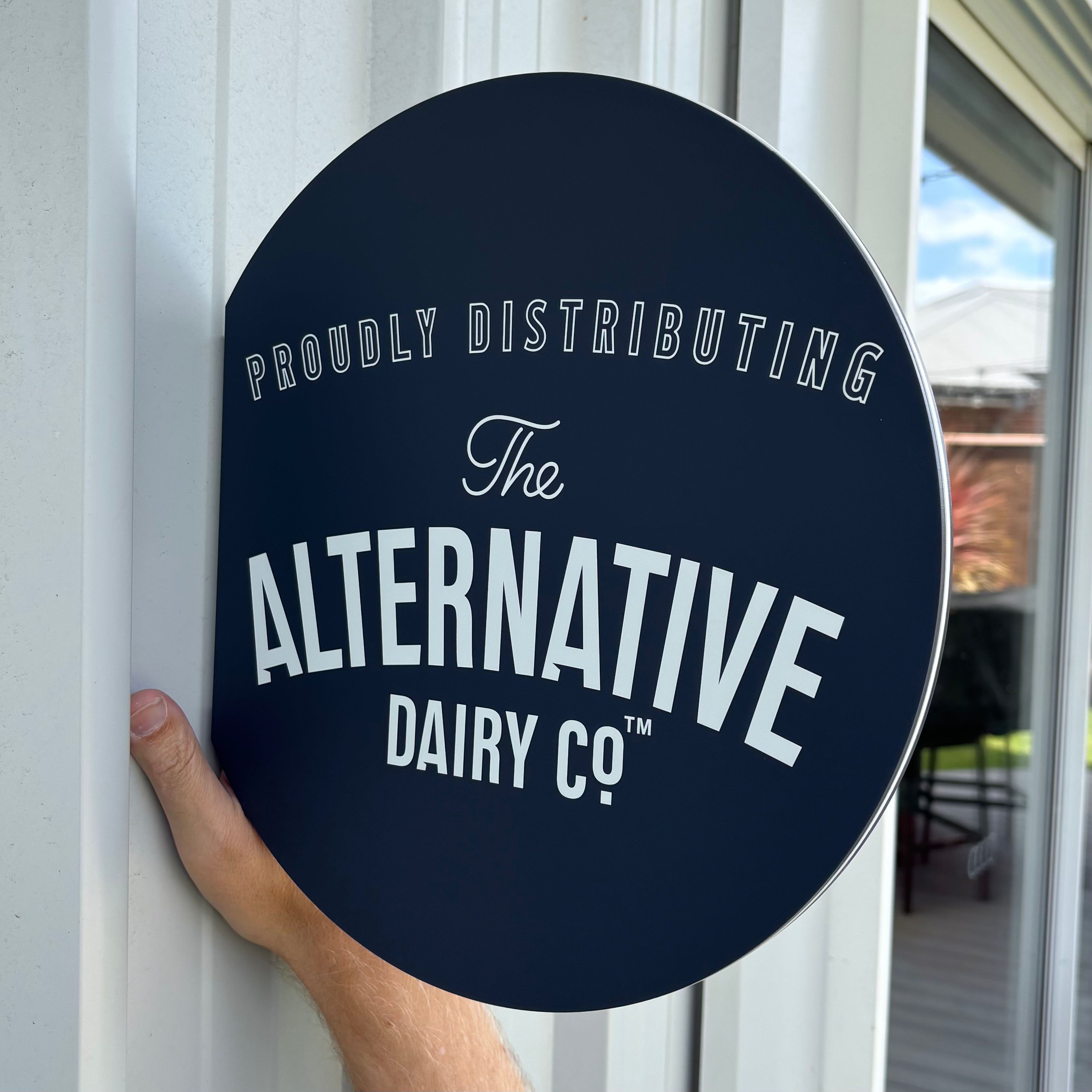 Round blade sign mounted perpendicular to a building exterior, featuring a custom acrylic business sign for café and retail storefront visibility