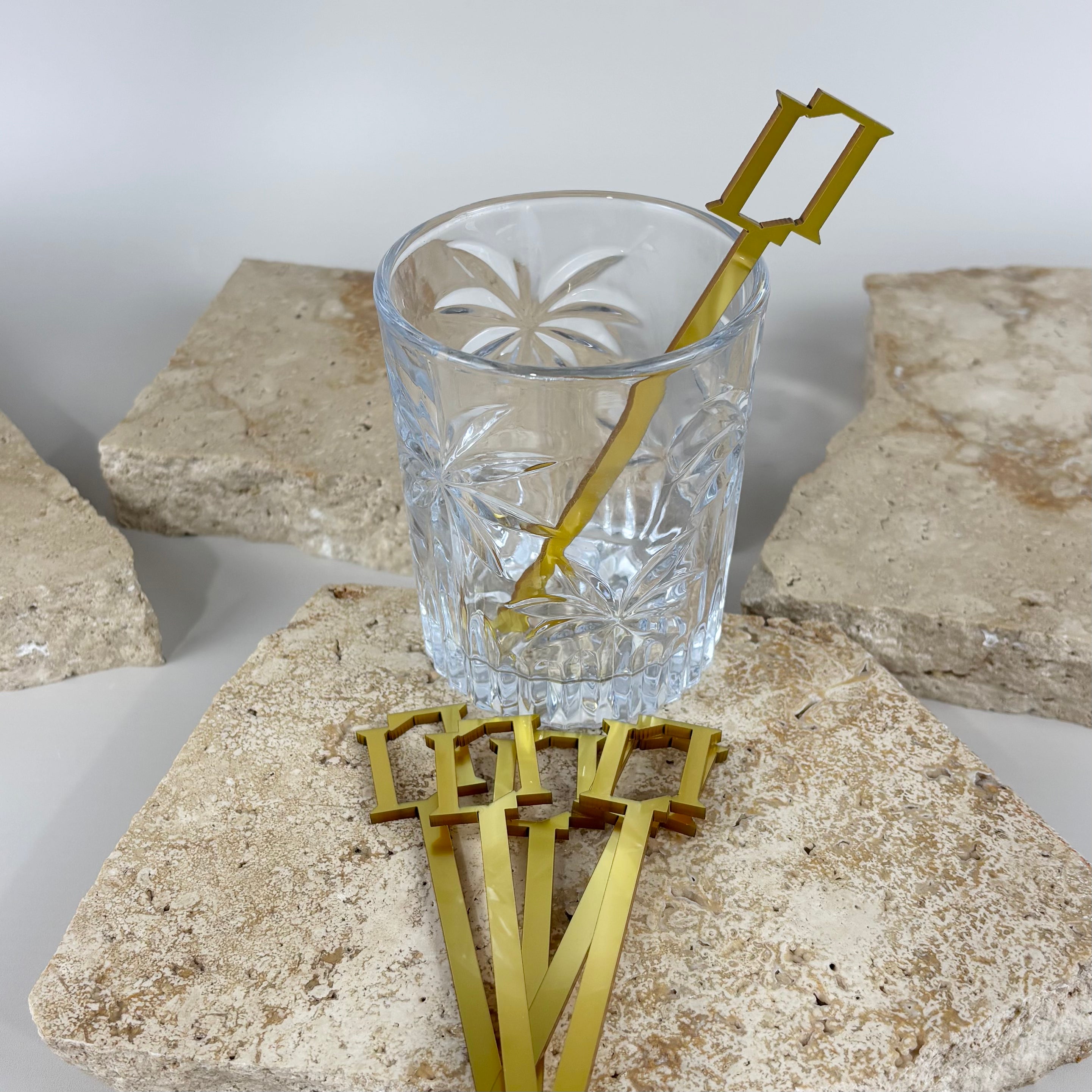 Gold acrylic drink stirrers in crystal cocktail glass