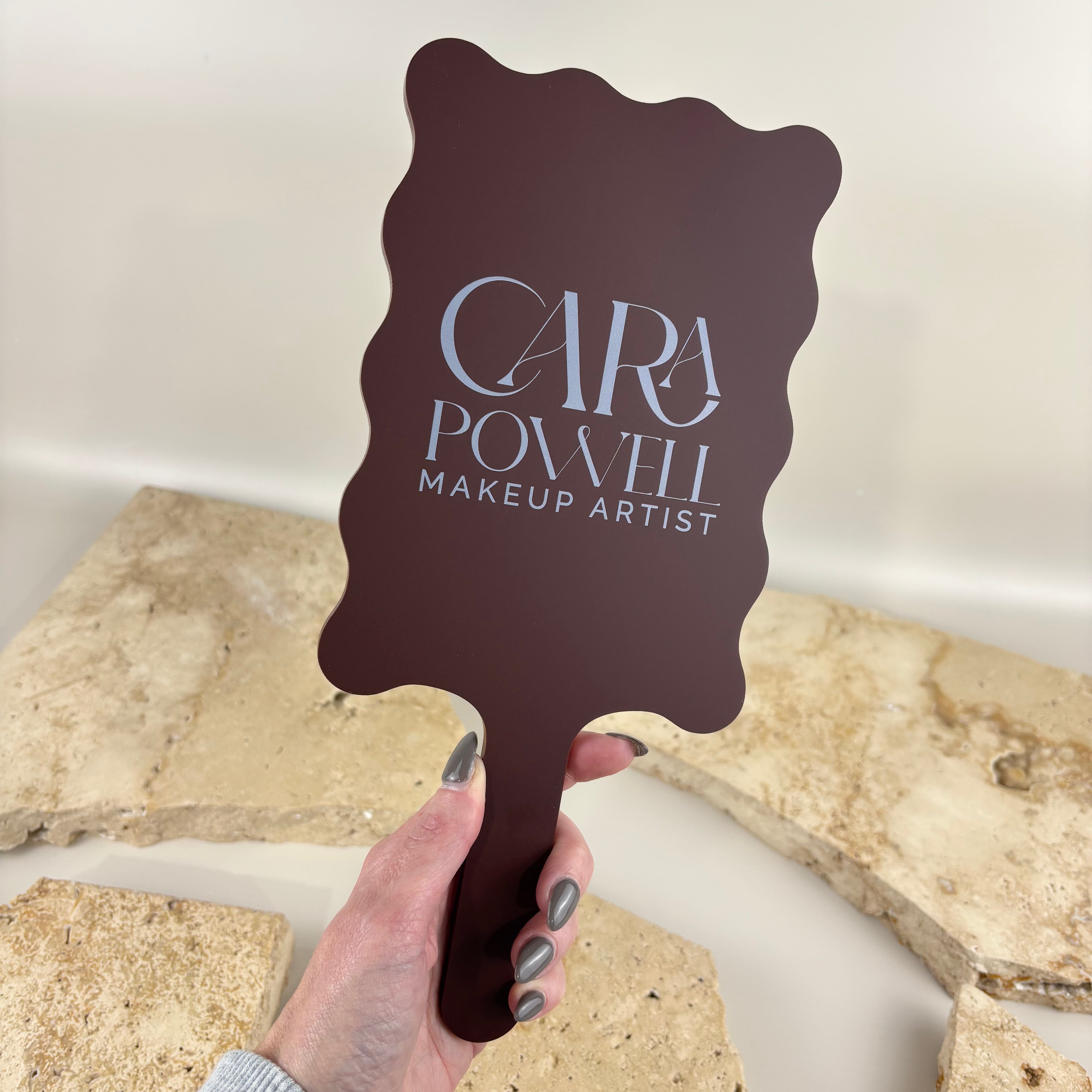 Custom handheld makeup artist mirror with UV printed business logo, wavy acrylic beauty mirror for makeup artists, beauty salons, cosmetic studios, bridal makeup, mobile makeup artists and professional beauty branding.
