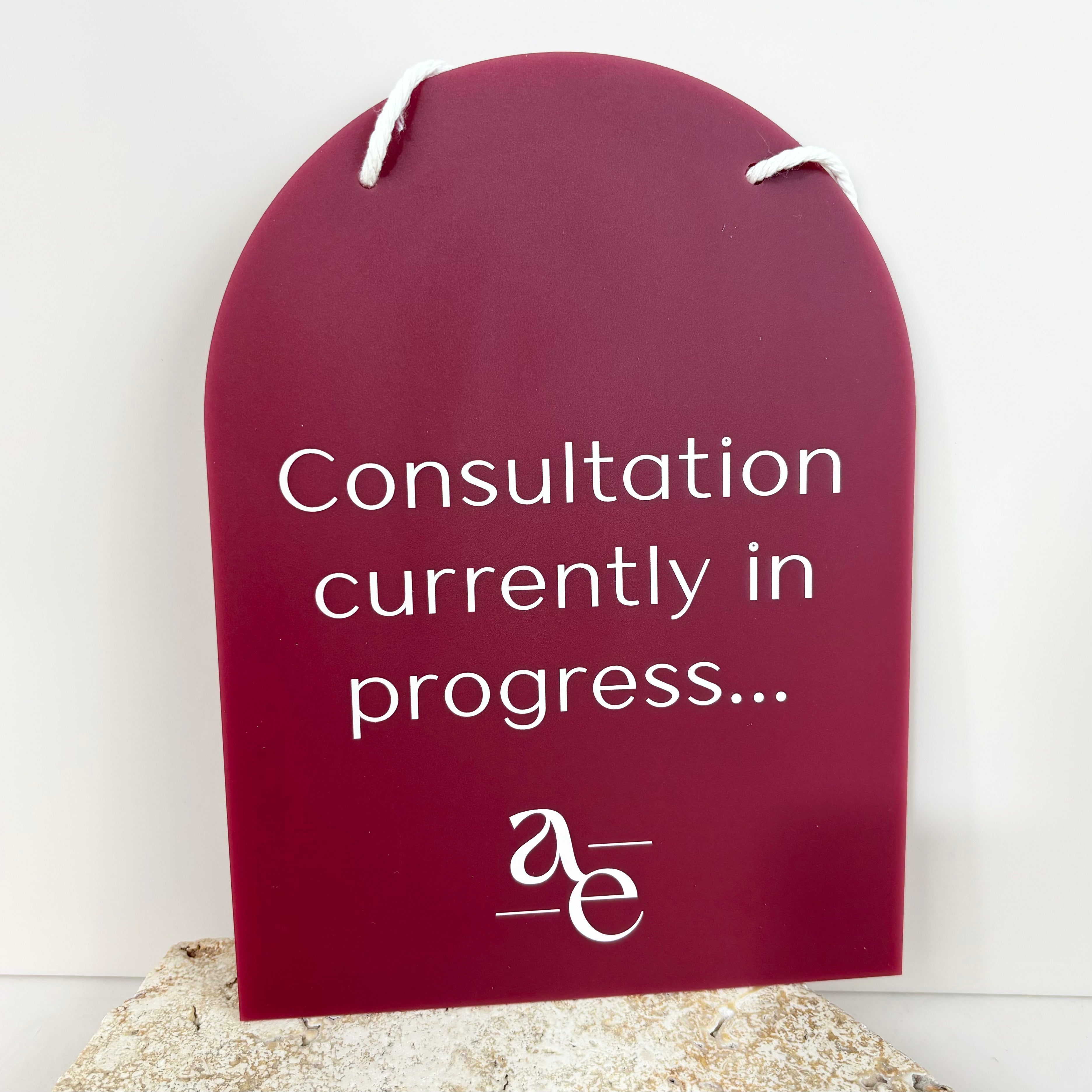 Purple mini arched beauty salon door plaque reading “Consultation currently in progress…” on white background