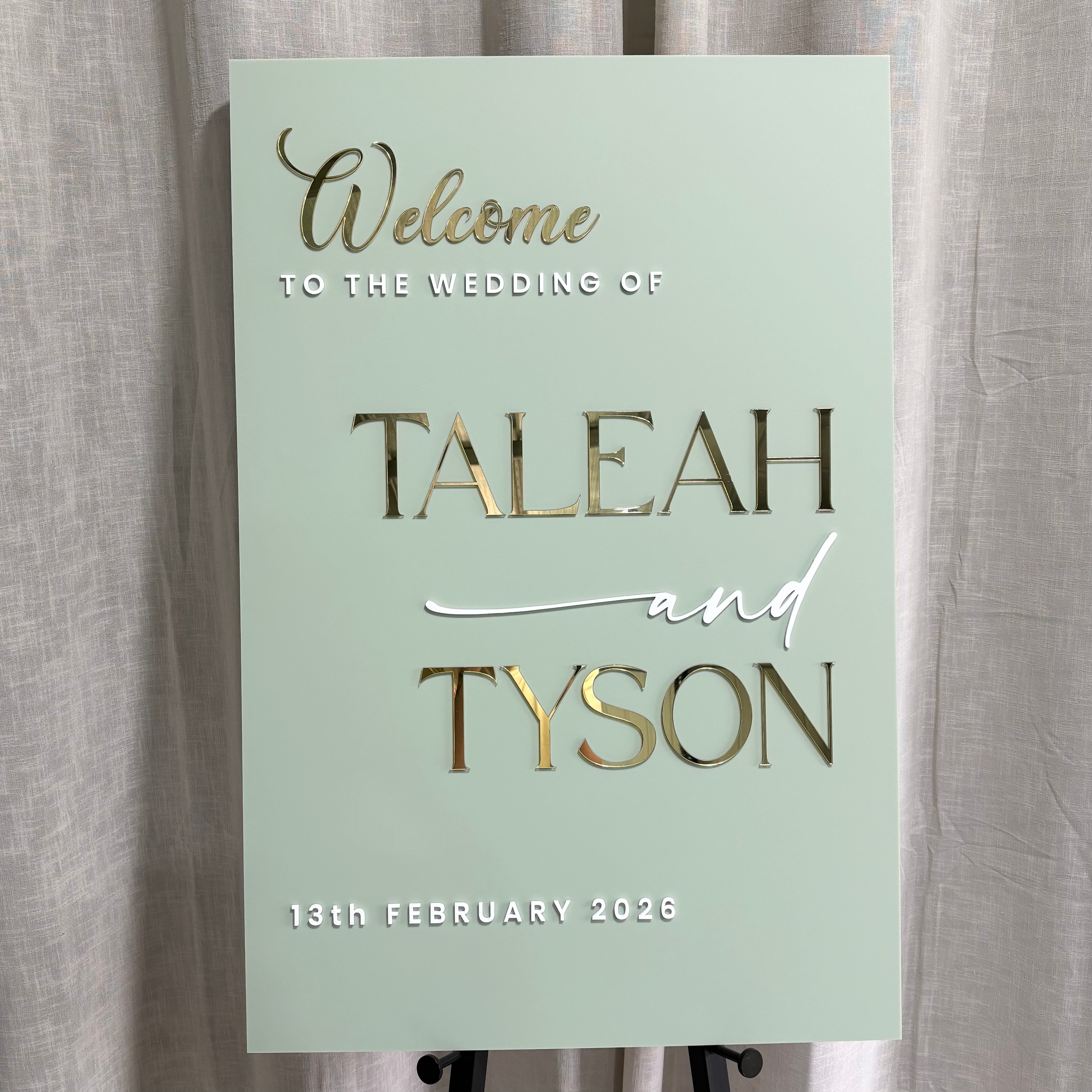Custom acrylic wedding welcome sign with raised gold mirror lettering, personalised wedding signage for ceremony and reception entrances, elegant modern wedding sign ideal for indoor or outdoor venues, custom names and date display.