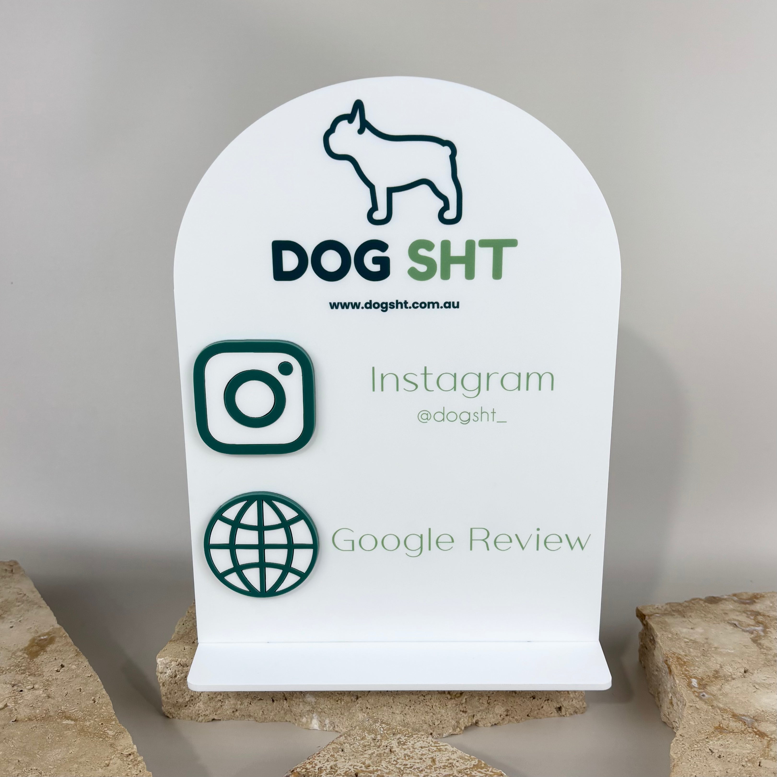 White acrylic business display sign for DOG SHT featuring a French bulldog logo, website address, Instagram handle @dogsht_, and a Google Review icon, styled in green and dark blue text with 3D raised acrylic details.