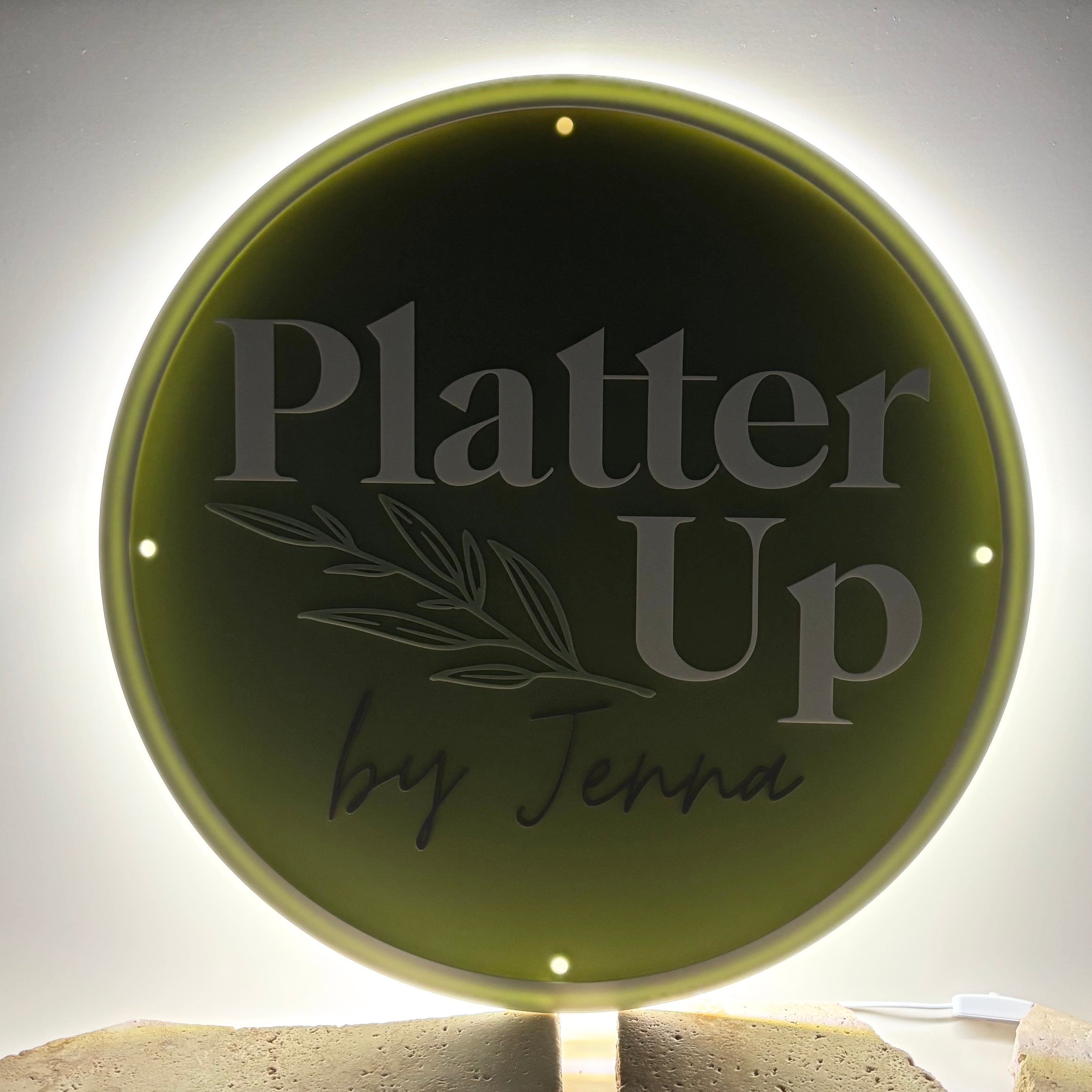 Illuminated round acrylic sign with etched text “Platter Up by Jenna” – custom indoor wall sign