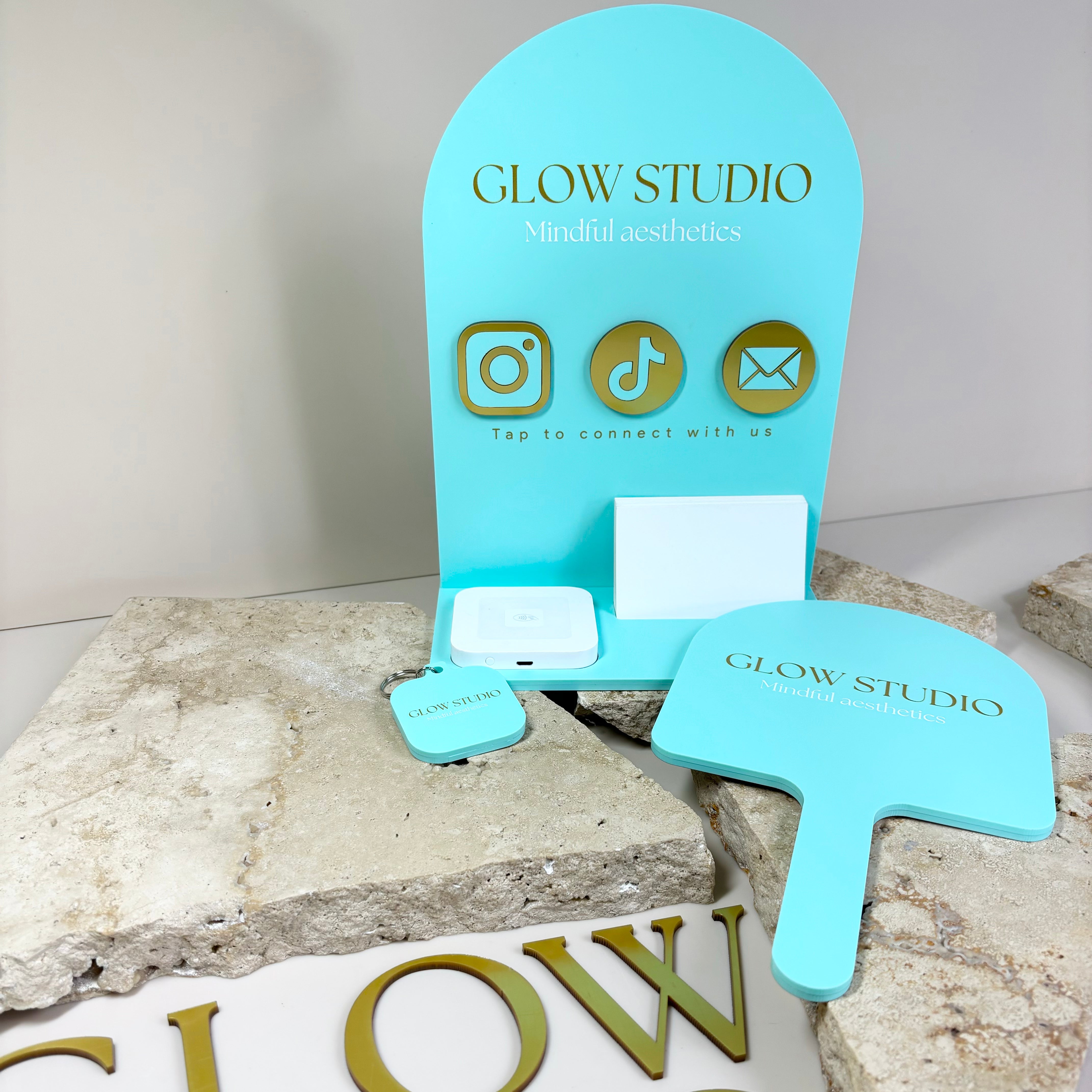 Glow Studio turquoise acrylic business signage set with handheld mirror and custom NCF stand and keychain with lettering sign