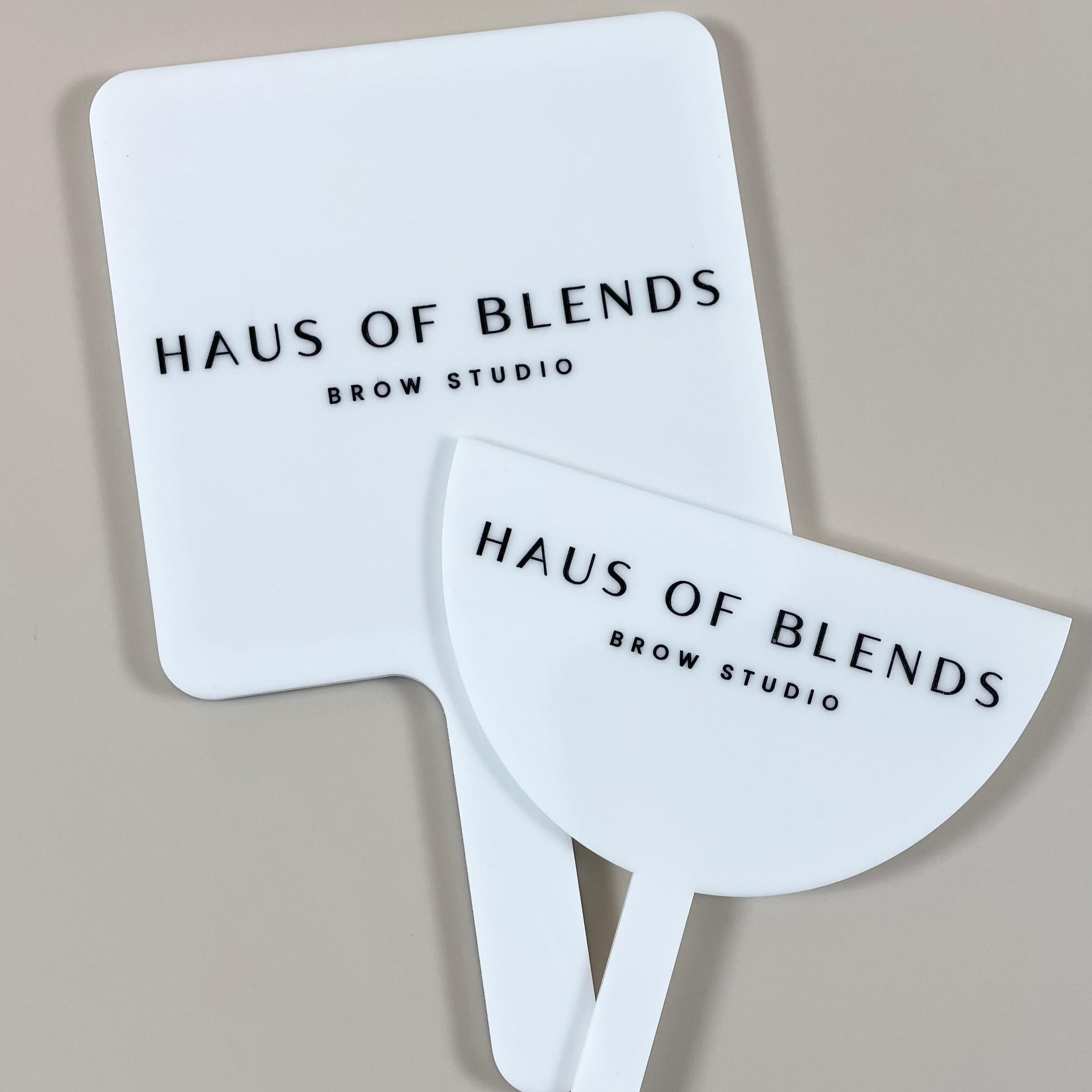 Minimalist white mirror and face shield with Haus of Blends logo, ideal for clean salon aesthetics