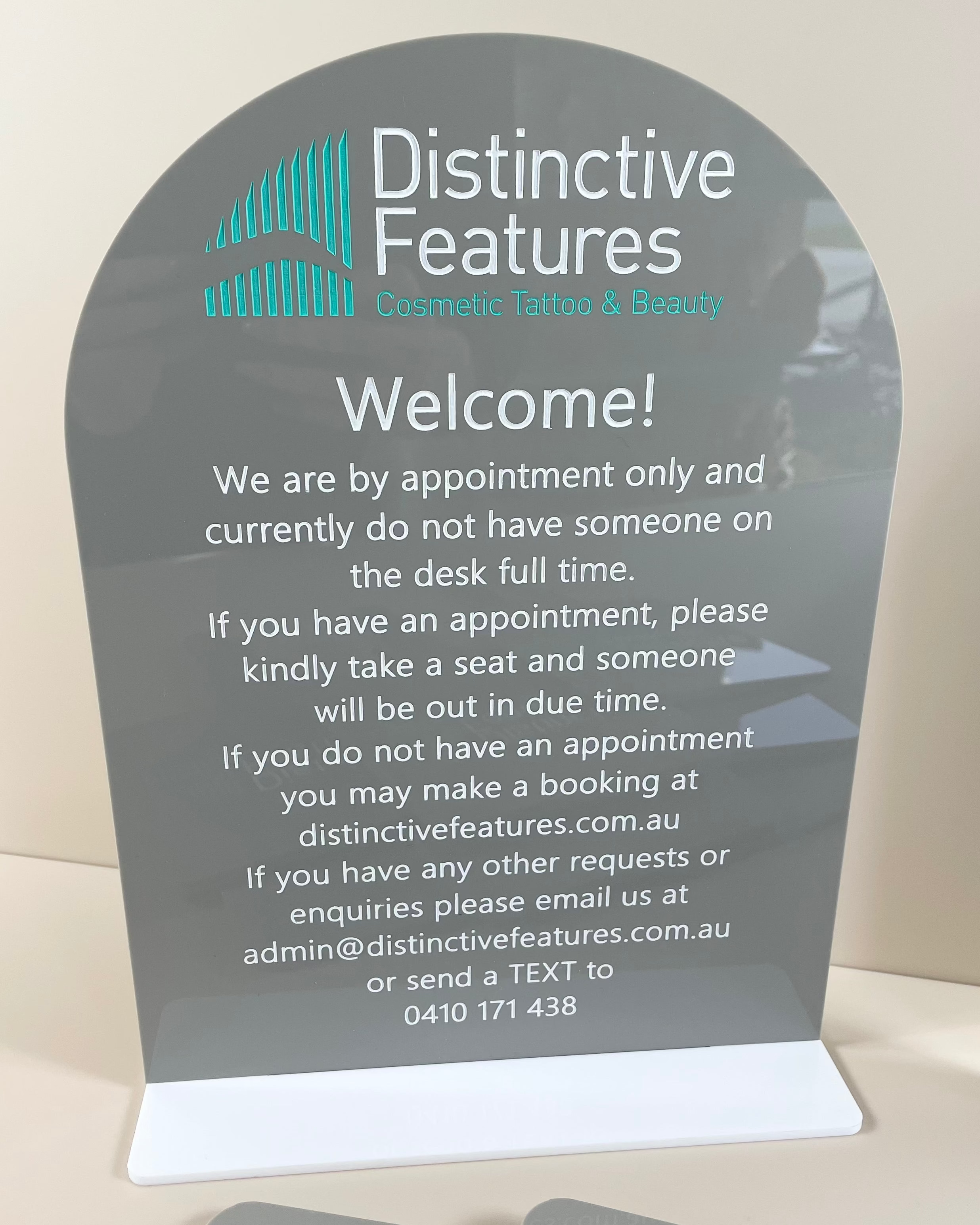 Grey welcome sign with business information and brand logo