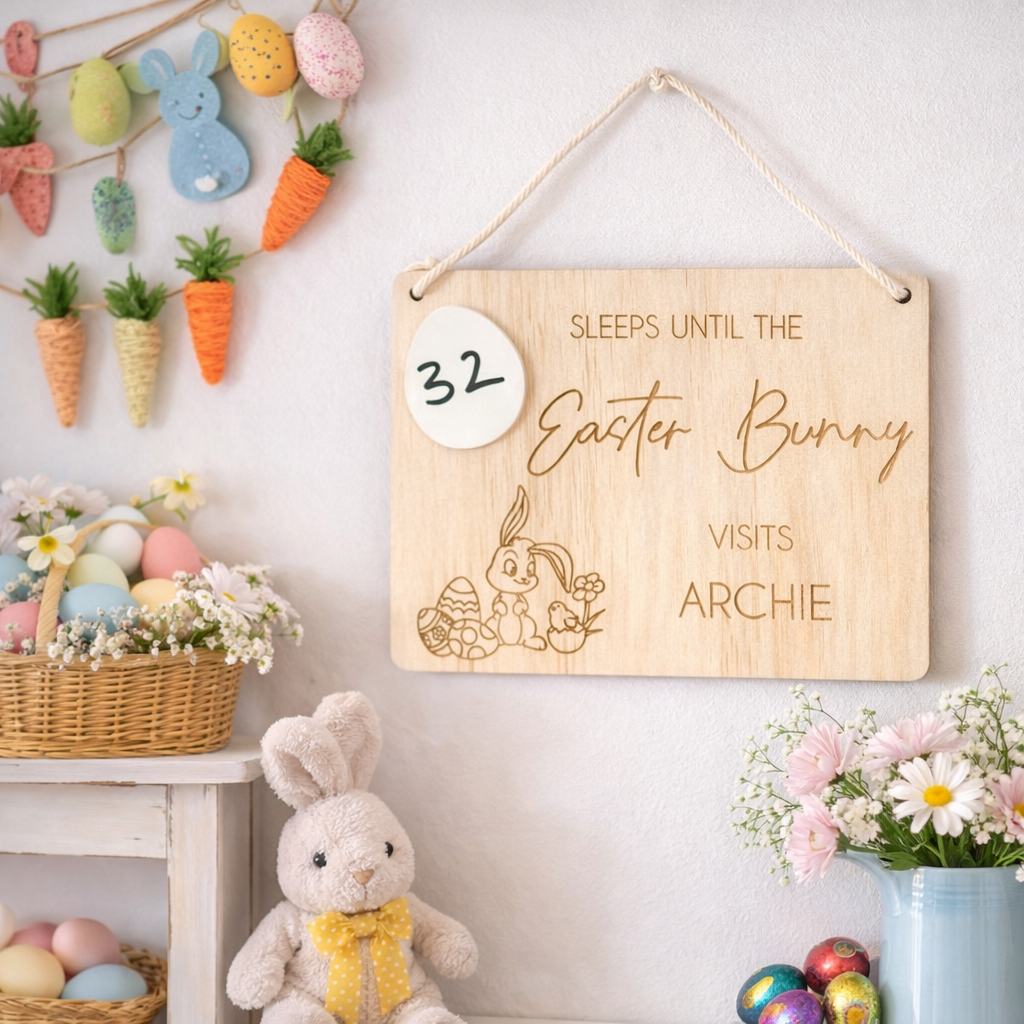 Wooden Easter countdown sign reading “Sleeps until the Easter Bunny visits Archie” displayed on a homely Easter wall with pastel eggs, bunny decor and spring flowers