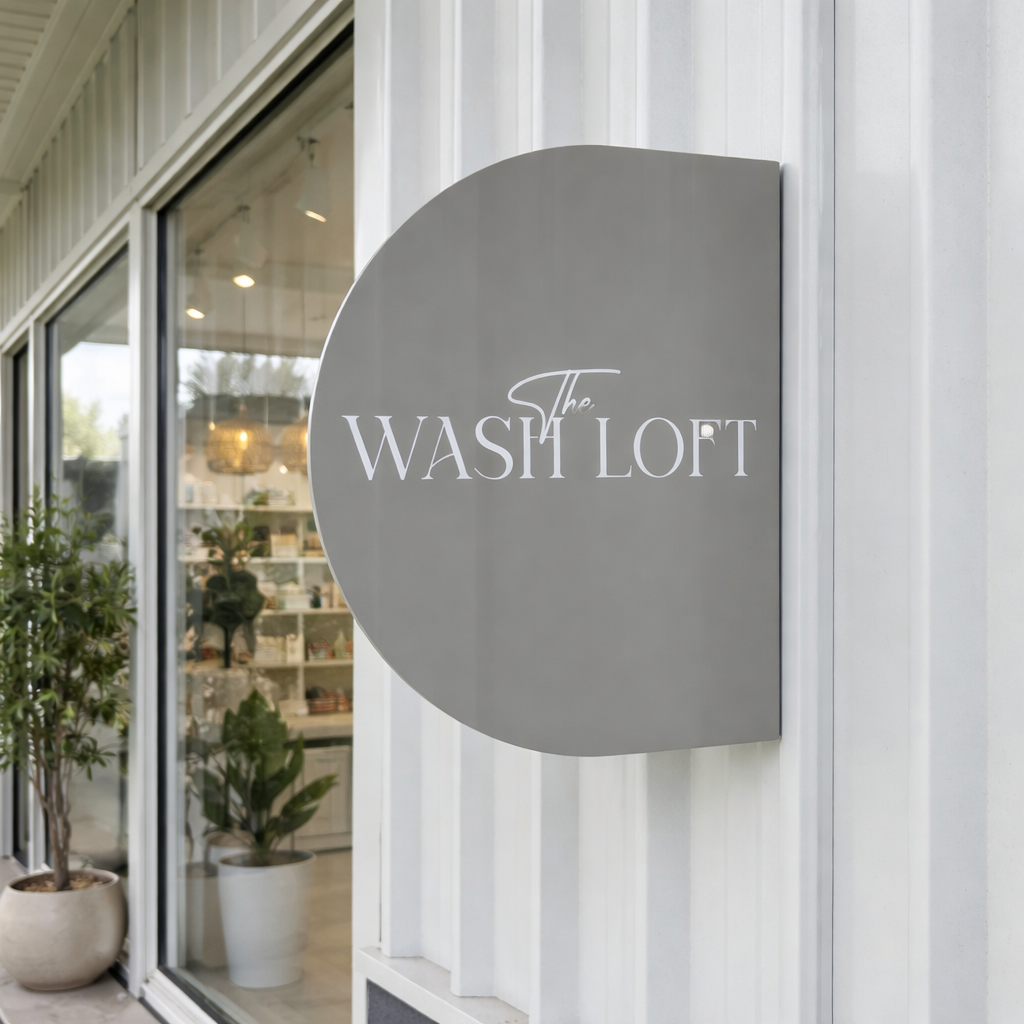 Modern arched acrylic blade sign mounted outside a retail storefront featuring raised business lettering, custom exterior shop signage for salons, boutiques and small businesses, Australian made blade sign.