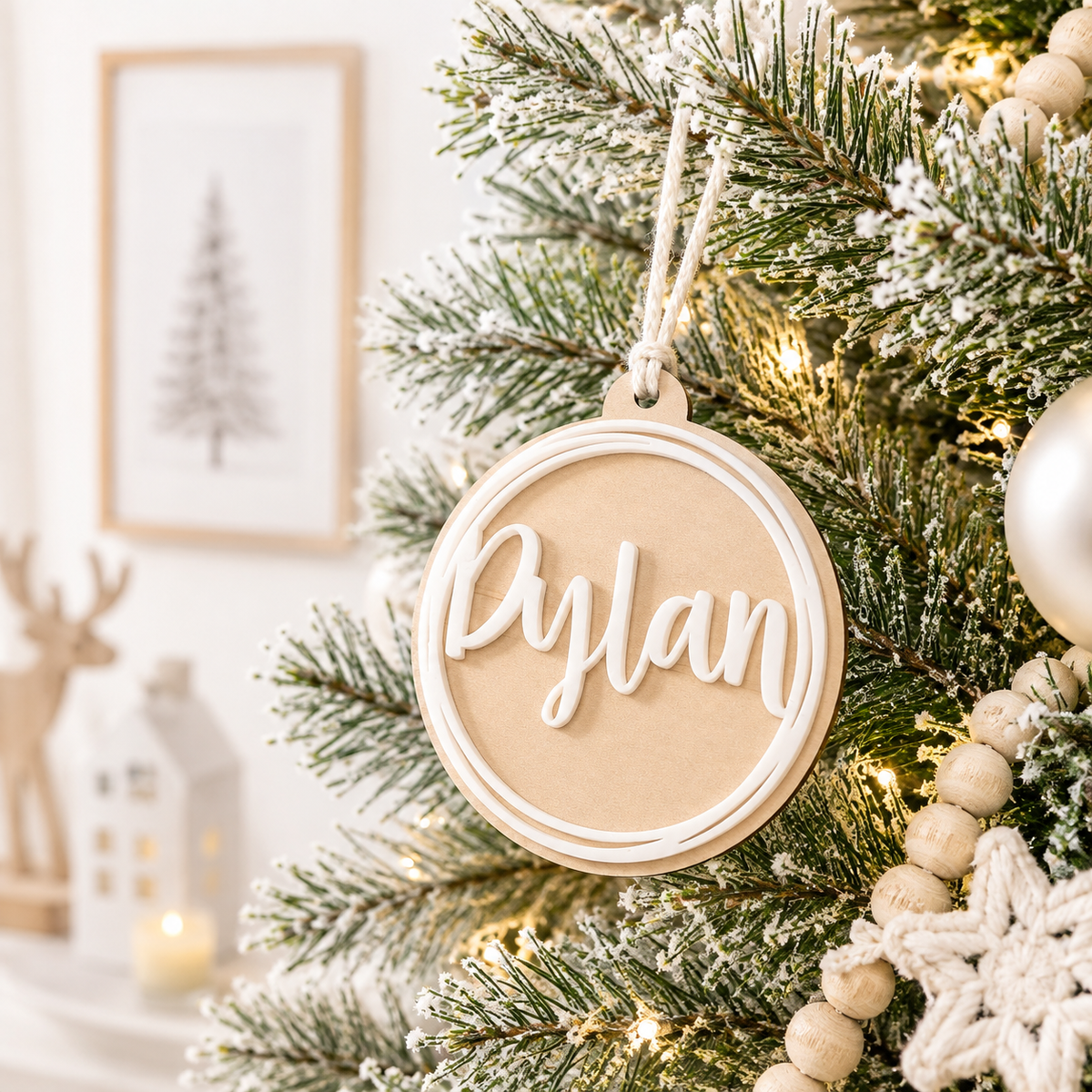 Personalised wooden Christmas bauble with raised white acrylic name and circular border, custom Christmas tree ornament with modern neutral design.