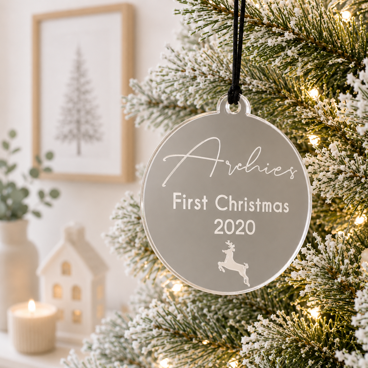 Personalised mirror acrylic First Christmas bauble with custom name, year and reindeer engraving, hanging on a modern Christmas