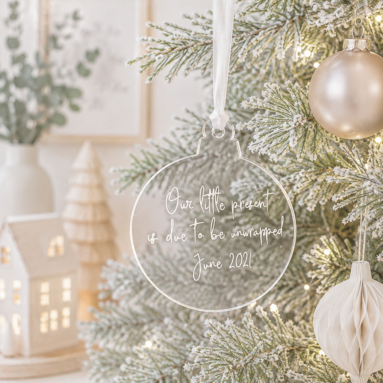 Personalised clear acrylic pregnancy announcement Christmas bauble with “Our little present is due to be unwrapped” and custom due date.
