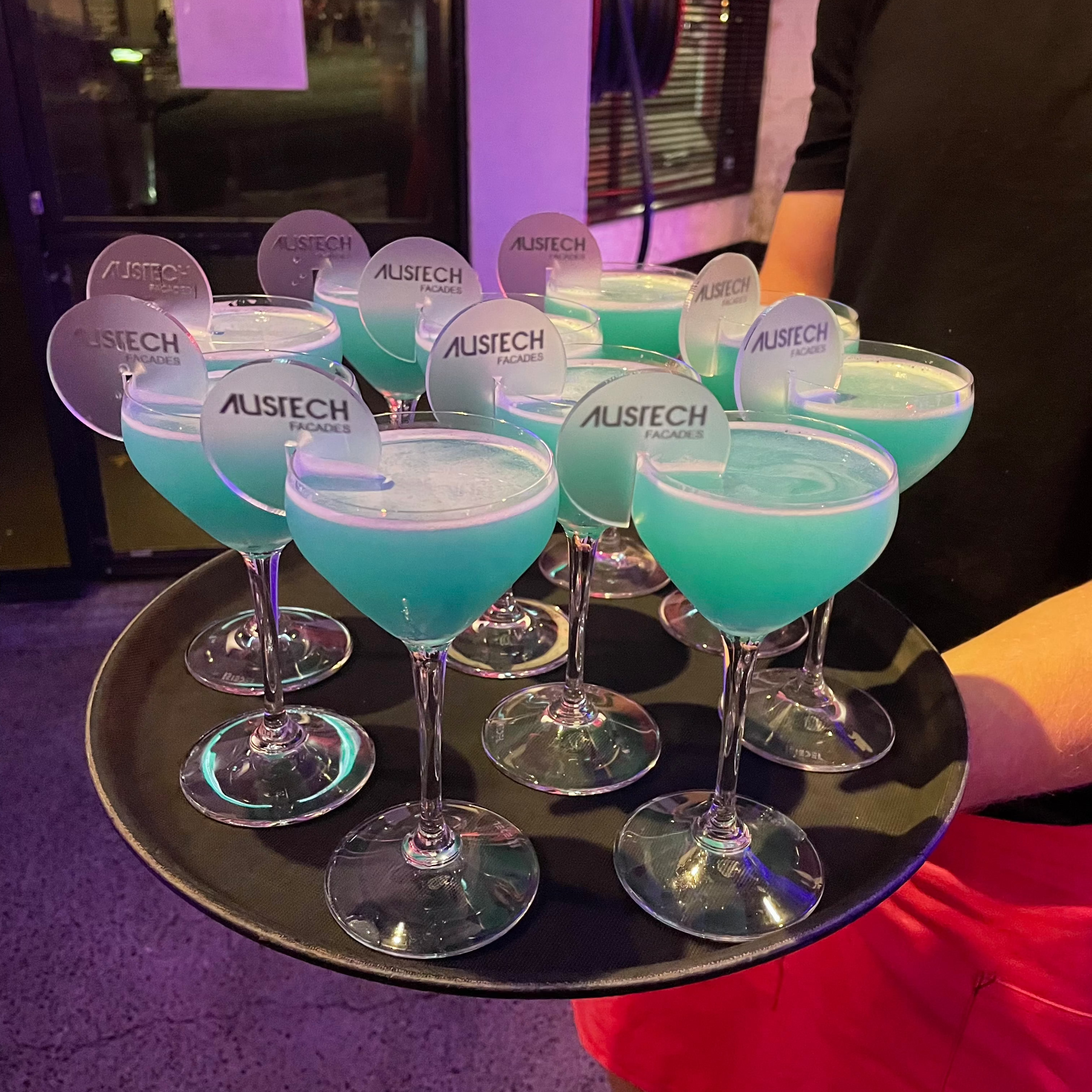 Multiple branded drink tags on glasses at a corporate function