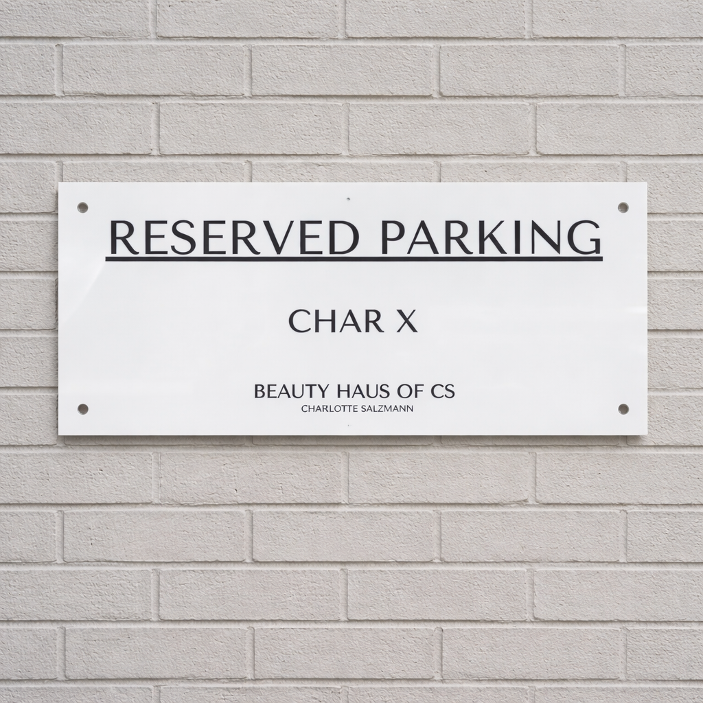 Reserved parking wall sign made from white acrylic with black engraved lettering, custom business parking bay sign mounted on exterior wall for beauty salon, personalised reserved parking signage Australia.