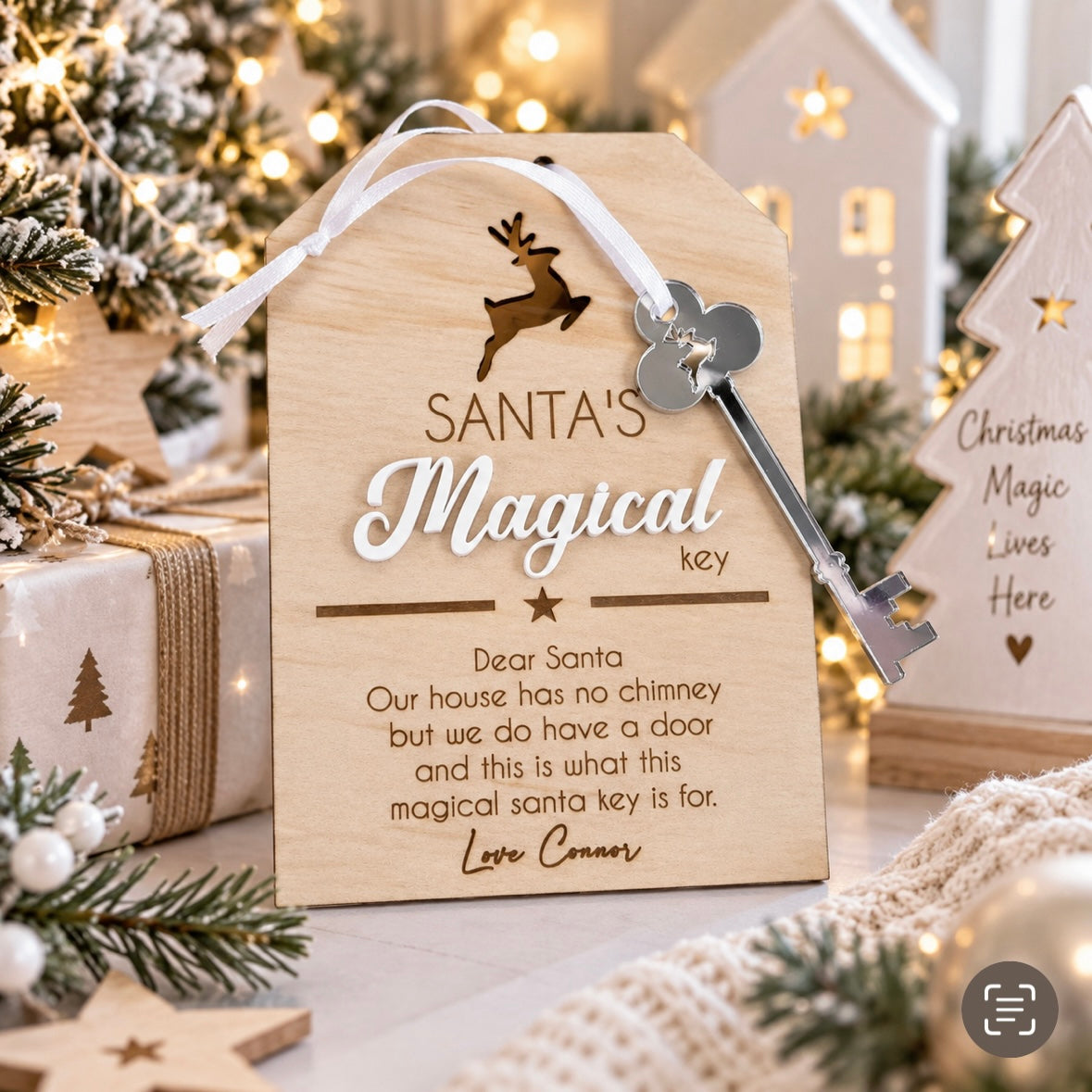 Personalised wooden Santa’s magical key Christmas decoration with silver acrylic key, displayed in a light modern Christmas setting with festive lights and decorations.