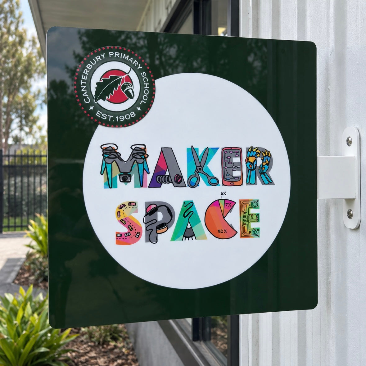 Custom square blade sign for Canterbury Primary School featuring colourful Maker Space artwork, mounted outdoors on a school building.