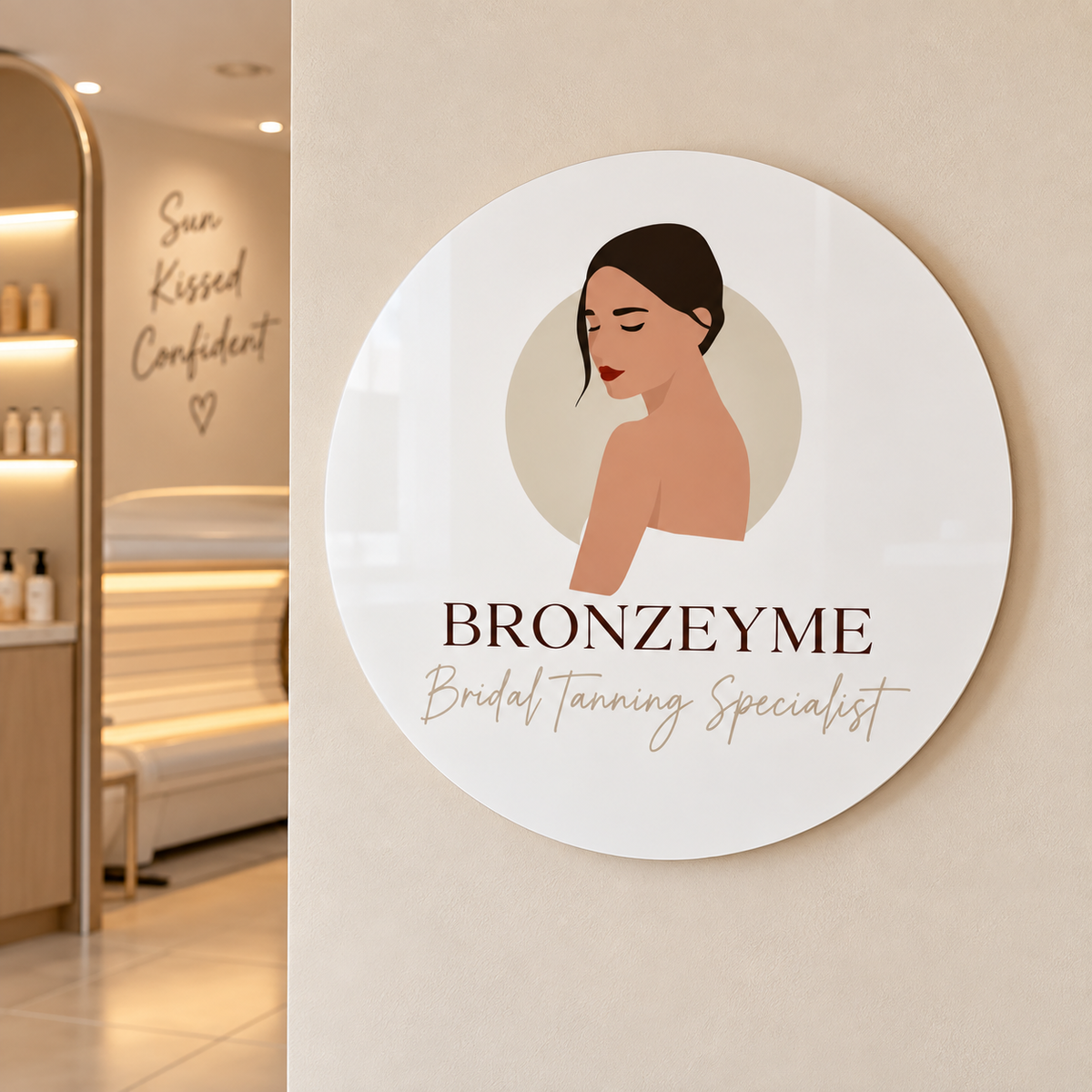 Custom 30cm round acrylic business sign for Bronzeyme Bridal Tanning Specialist, displayed on a modern tanning salon wall.