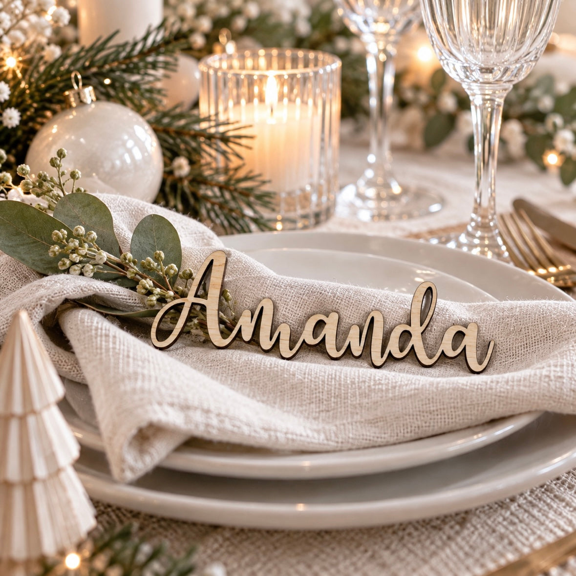 Laser cut wooden personalised name place card displayed on an elegant modern table setting with neutral linen, greenery and Christmas décor.