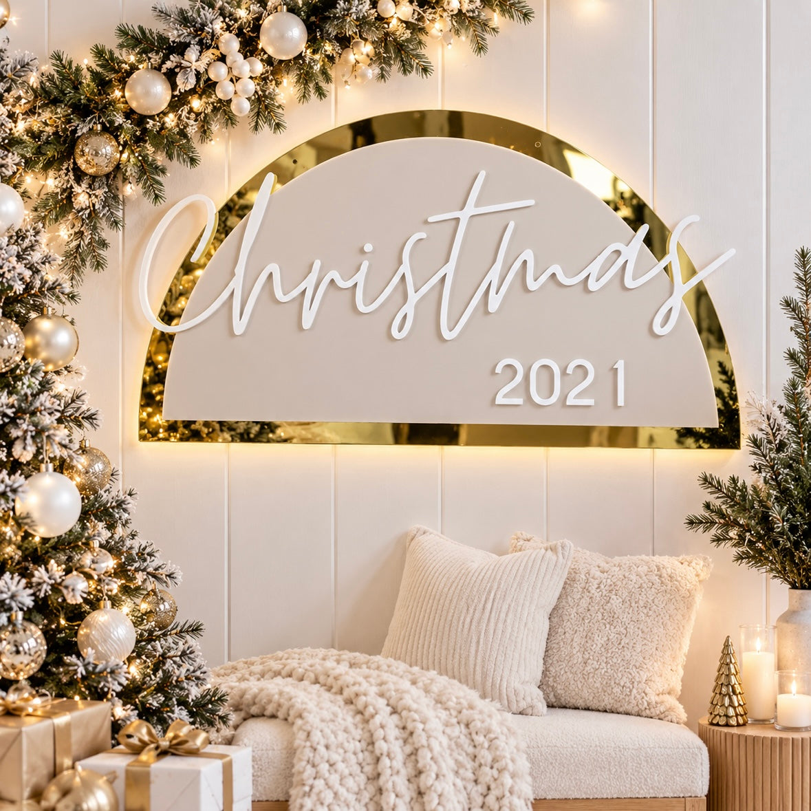Christmas photo prop sign with gold mirror acrylic and white Christmas 2021 lettering, displayed on a wall in a light modern festive setting.