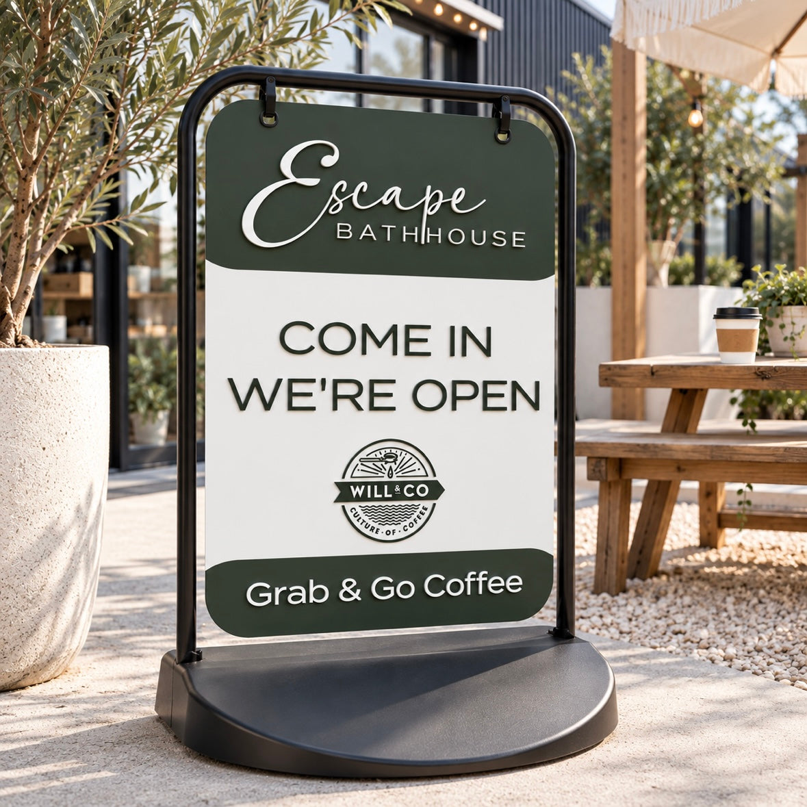 Custom outdoor pavement sign for Escape Bathhouse with café open signage and Grab & Go Coffee branding, displayed outside a modern café.