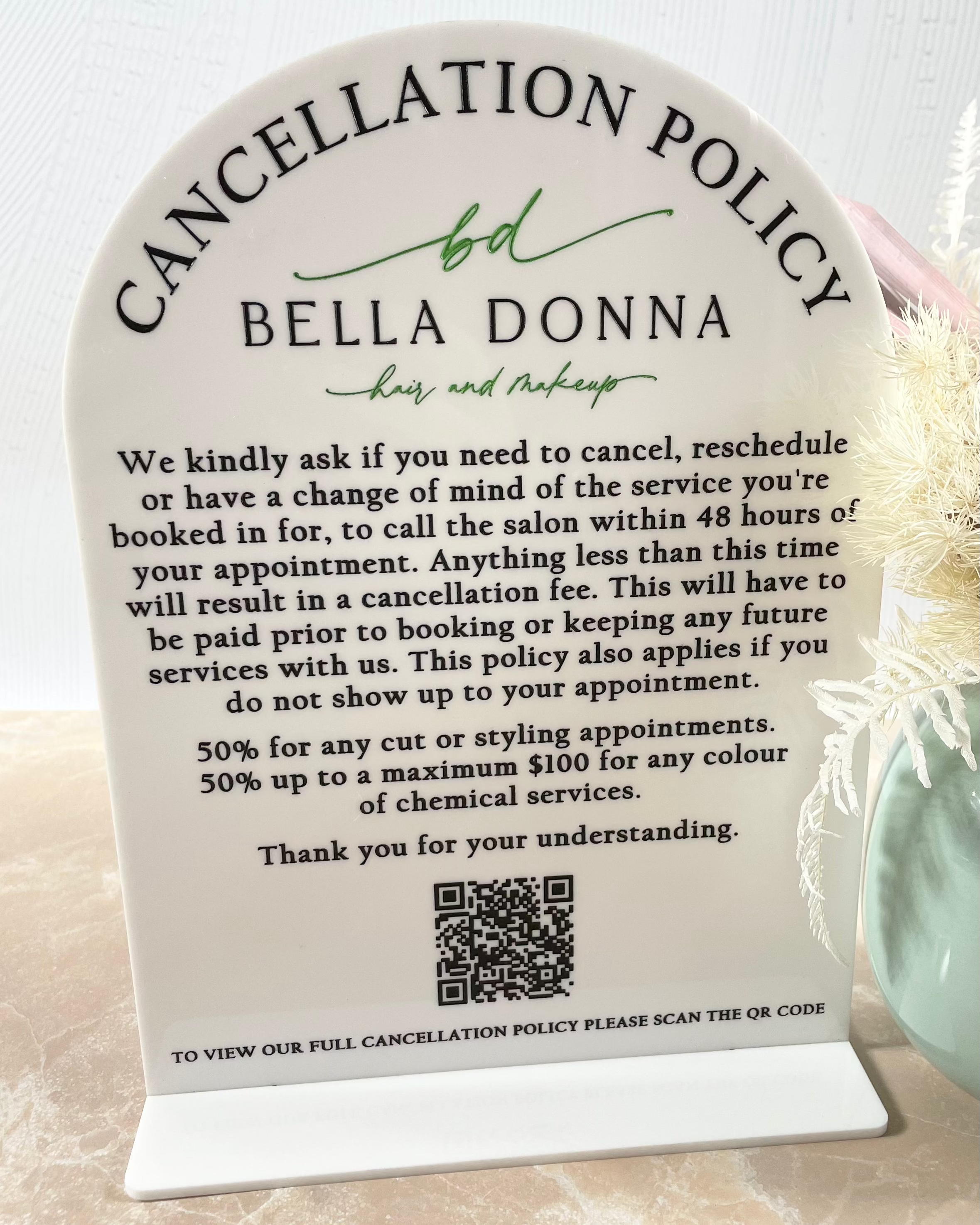 Cancellation policy sign with QR code on clear arched acrylic