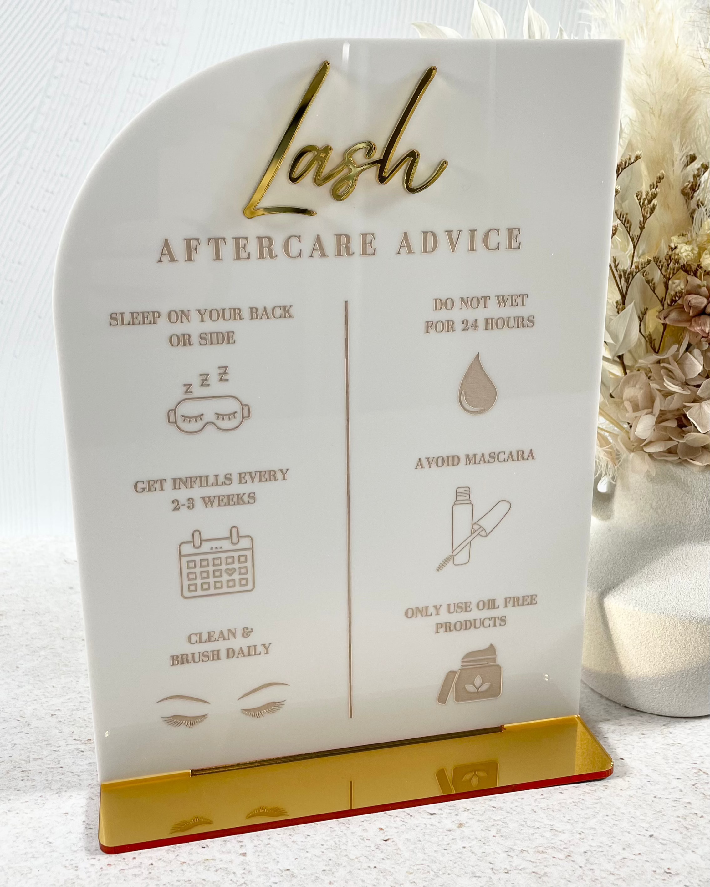 Neutral acrylic lash aftercare sign with gold base and icons