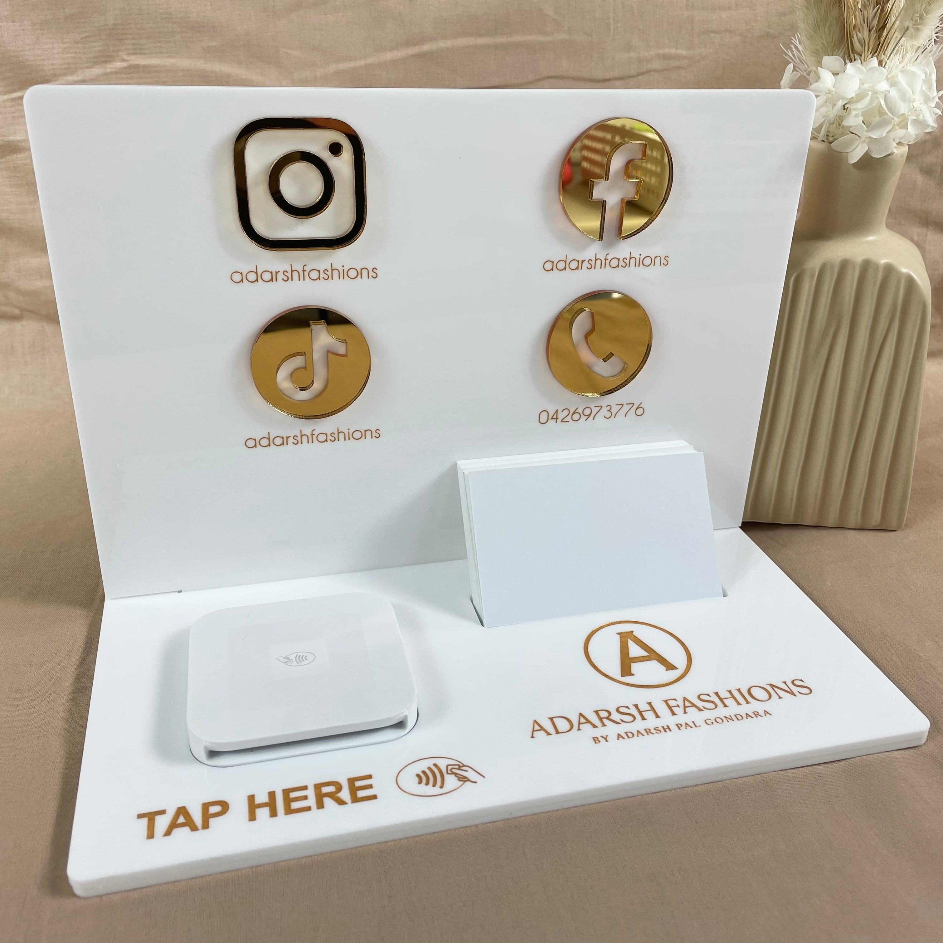 White and gold stand with Instagram, TikTok and Facebook logos