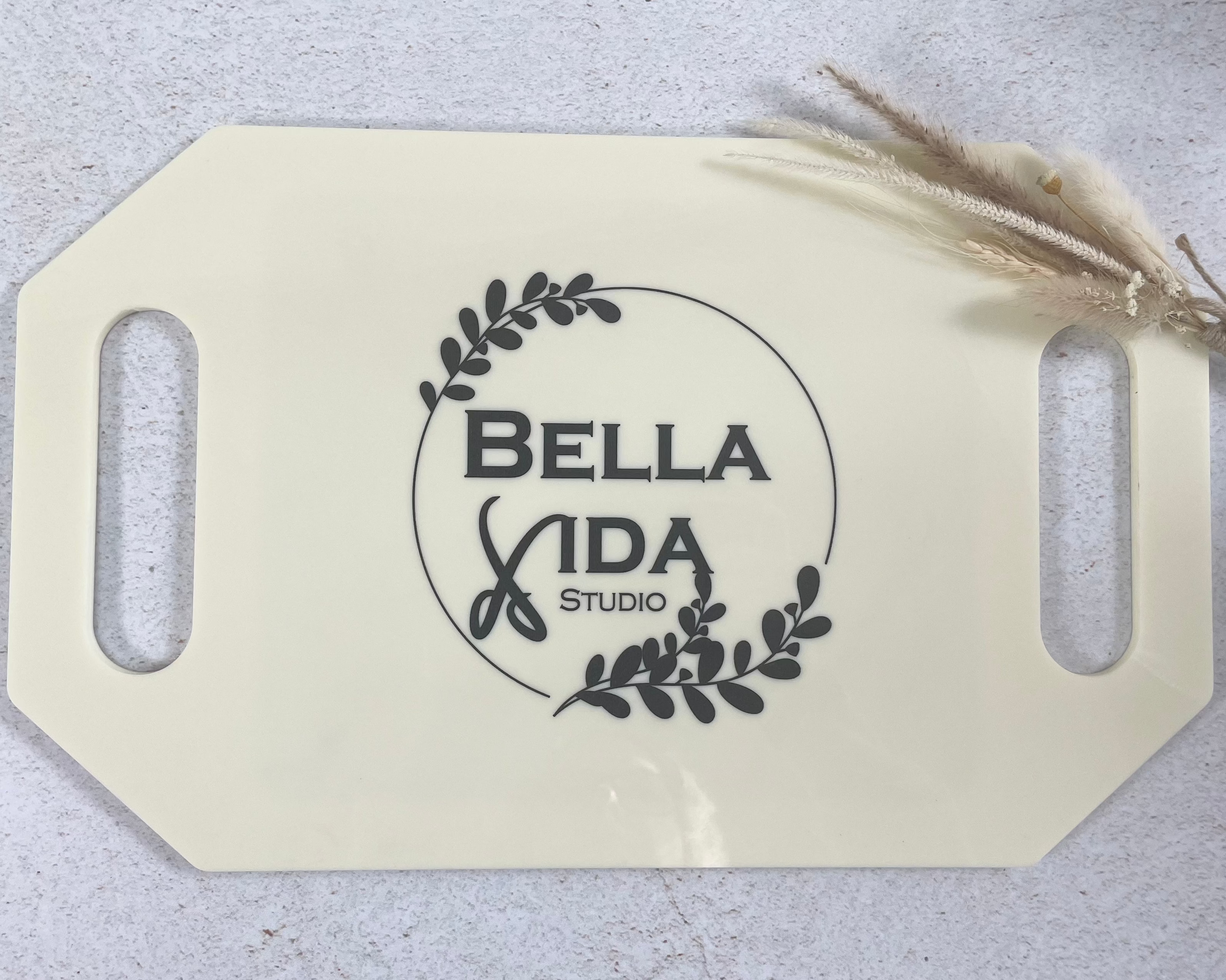 Bella Vida logo on grey branded salon mirror displayed on stone background